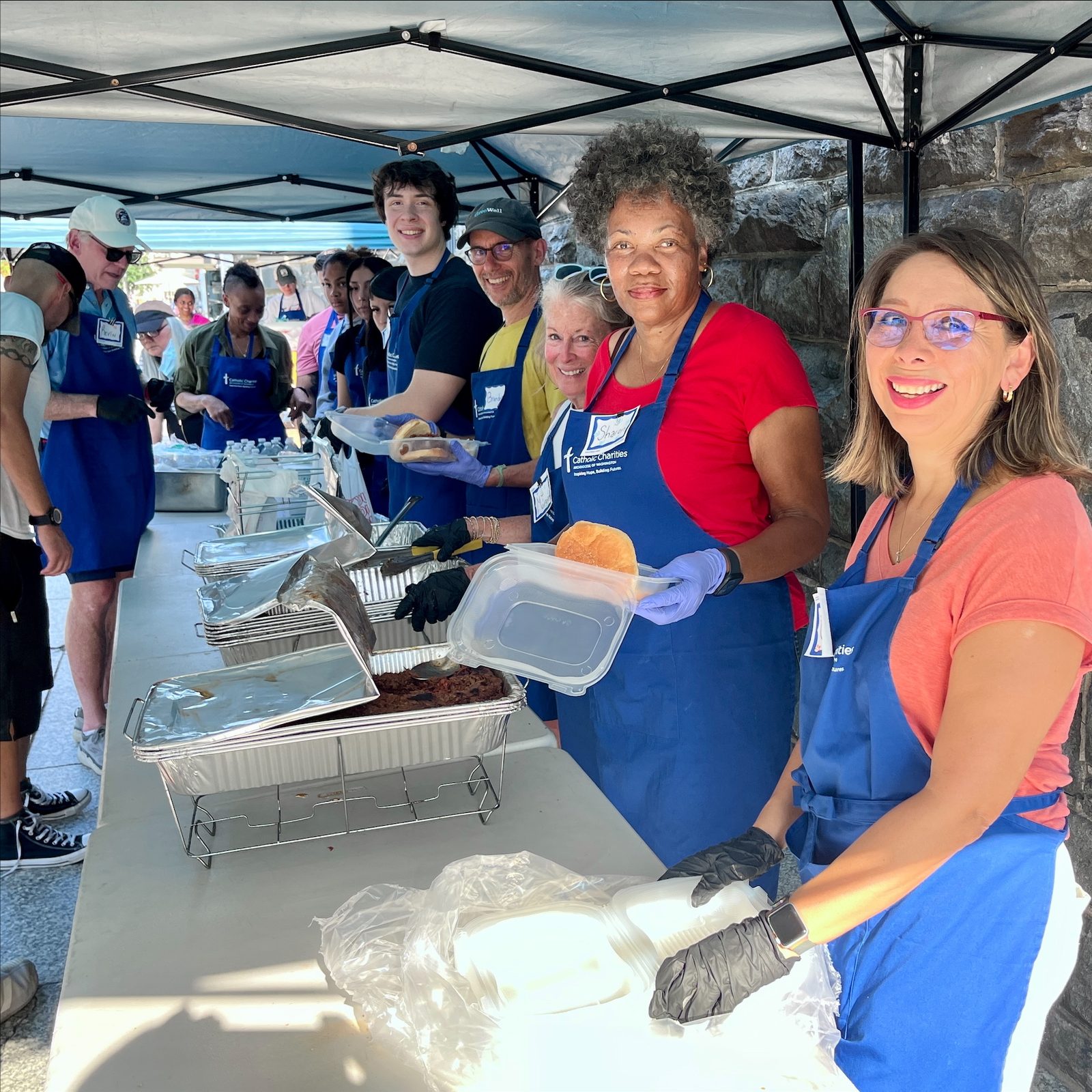 In a photo from July 2025, volunteers at Catholic Charities’ St. Maria’s Meals program outside the agency’s headquarters in downtown Washington, D.C., prepare to serve meals to the homeless and other guests experiencing food insecurity. The program on Wednesday afternoons serves tens of thousands of meals to guests annually. (Photo courtesy of Catholic Charities)