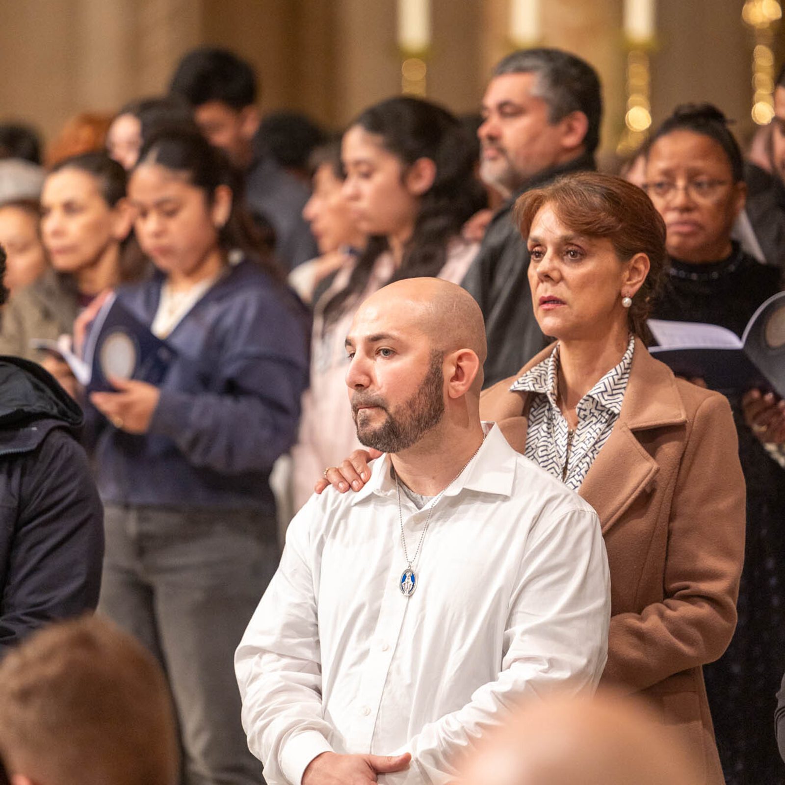 Godparents place their hands on the shoulders of catechumens during the Rite of Election at the Basilica of the National Shrine of the Immaculate Conception on Feb. 22, 2026. Catechumens – who became the elect during the rite – are people who have not yet been baptized, and they will receive the Sacraments of Initiation of Baptism, Confirmation and Communion at the Easter Vigil. (Catholic Standard photos by Mihoko Owada)