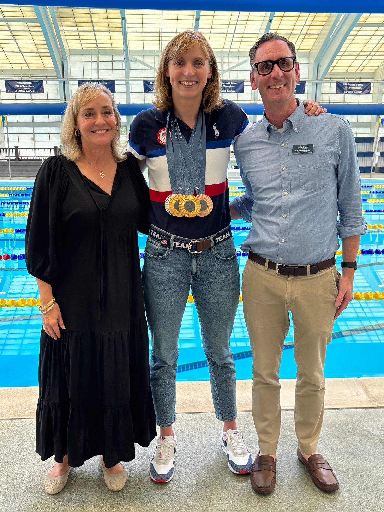 During Olympic swimming champion Katie Ledecky’s recent visit to her alma mater, Stone Ridge School of the Sacred Heart in Bethesda after the Paris Olympic Games, she posed for a photo with Catherine Ronan Karrels, Stone Ridge’s Head of School, and Malcolm McCluskey, the Head of the Upper School there. (Photo by Kate Kalas/Stone Ridge School of the Sacred Heart)