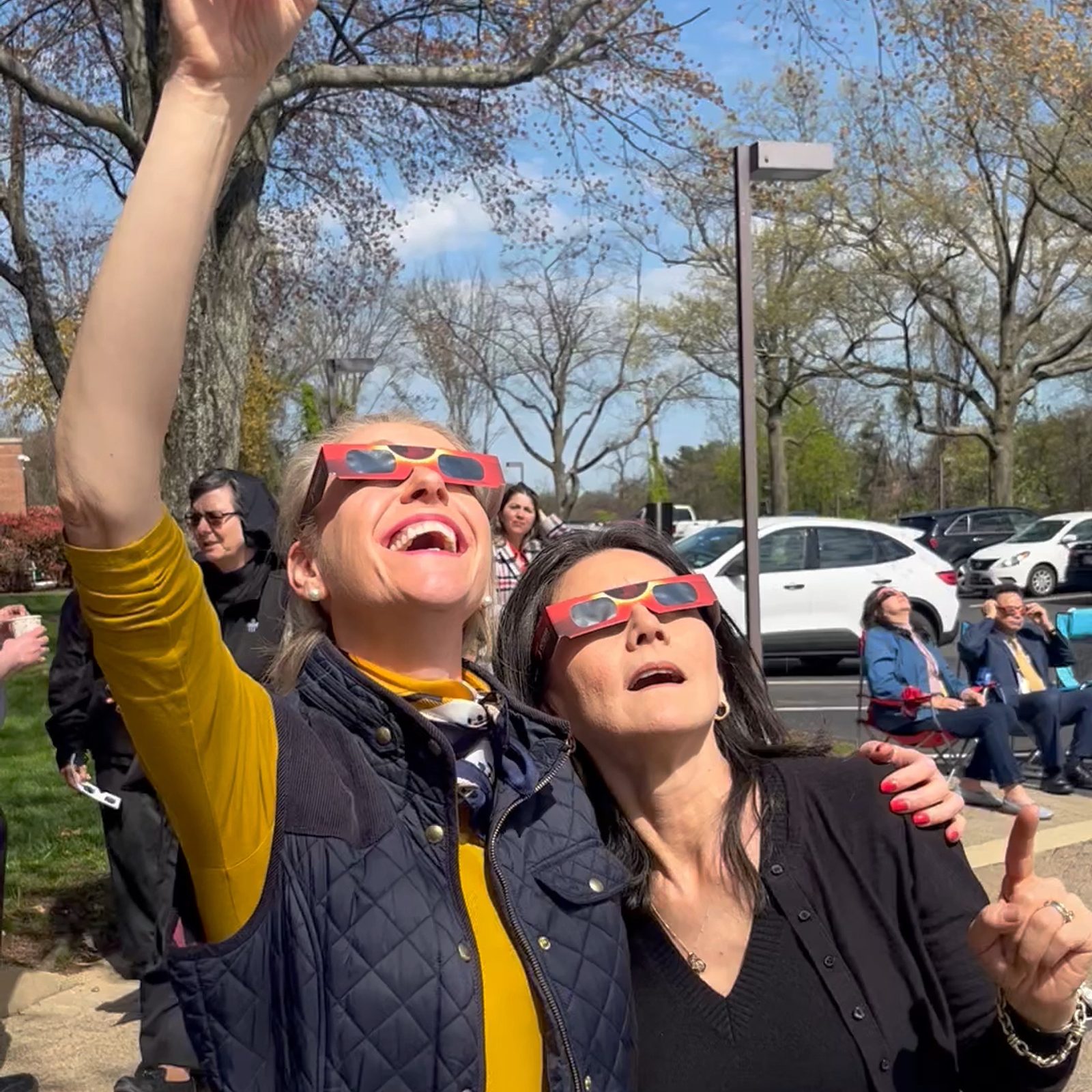 Georgina Stark of the Secretariat of Communications for The Roman Catholic Archdiocese of Washington and Claudia Bartolini of the Office for Cultural Diversity and Outreach watch the solar eclipse on April 8, 2024 outside the Archdiocesan Pastoral Center in Hyattsville, Maryland. (Catholic Standard photo by Mark Zimmermann)