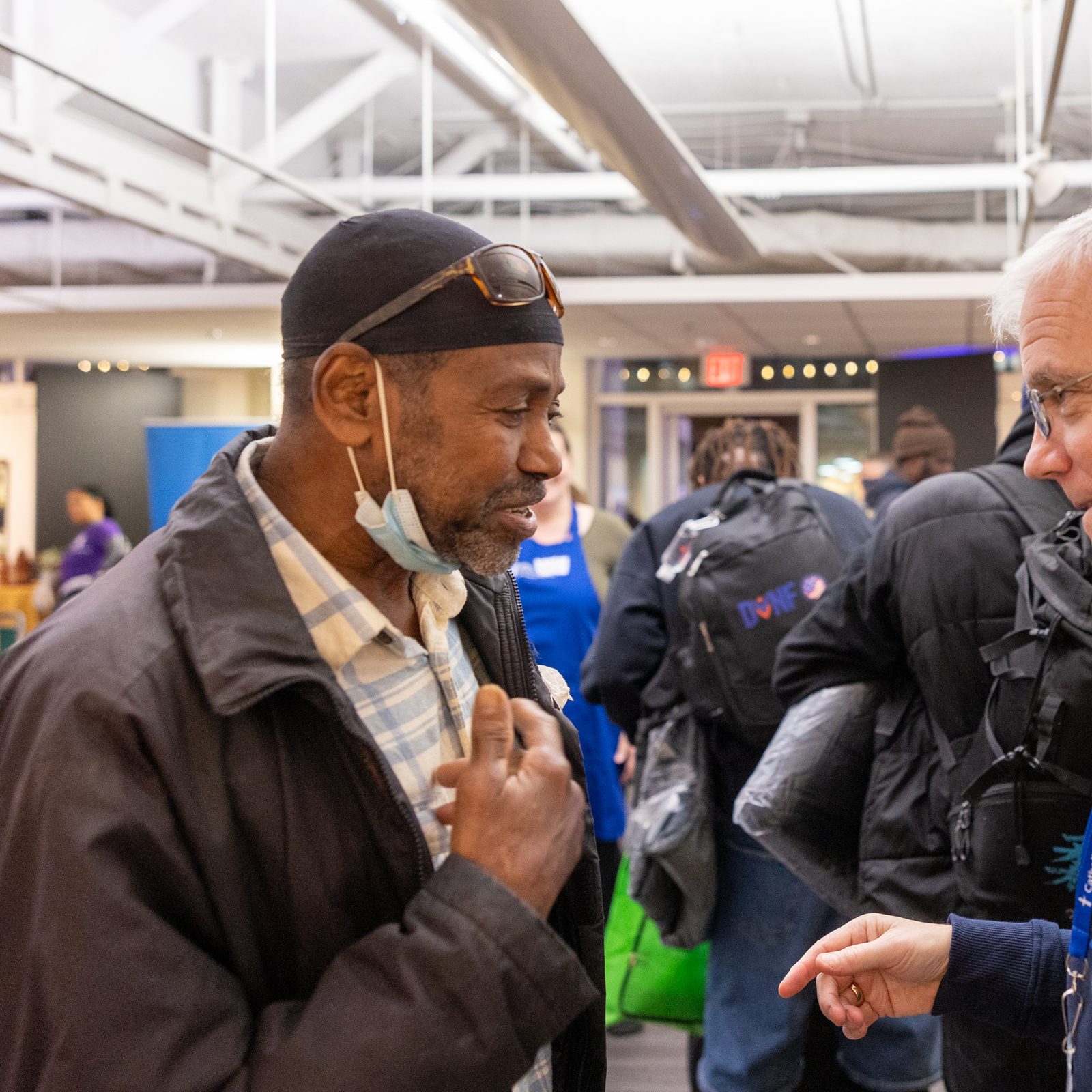 Jim Malloy (at right), the president and CEO of Catholic Charities of The Roman Catholic Archdiocese of Washington, talks with a man at the Nov. 26 Thanksgiving dinner given through Catholic Charities’ St. Maria’s Meals program and hosted by Pepco at its Edison Place Gallery in downtown Washington, D.C. (Catholic Standard photos by Mihoko Owada)