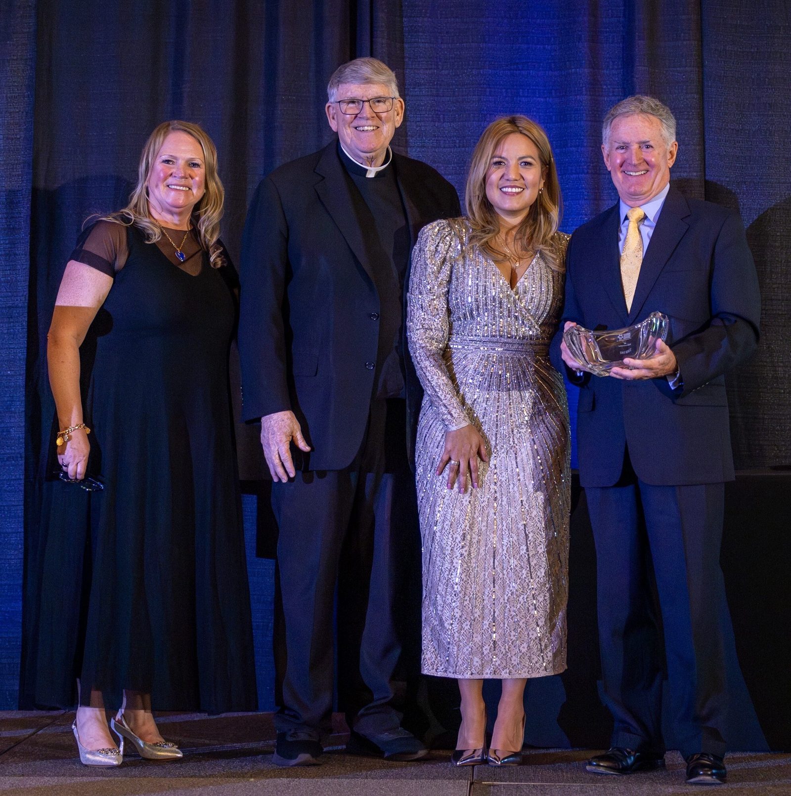 John B. Veihmeyer (at right) received the Businessperson of the Year Award at the Catholic Business Network of Montgomery County’s Gala on Nov. 22 at the Bethesda North Marriott Hotel & Conference Center. Joining him for the photo above were Susan Apgood (at left) the emcee at the gala; Msgr. John Enzler (second from left), who introduced Veihmeyer as the award recipient; and Greta Vento (second from right) the president of CBN-MC. (Catholic Standard photo by Mihoko Owada)