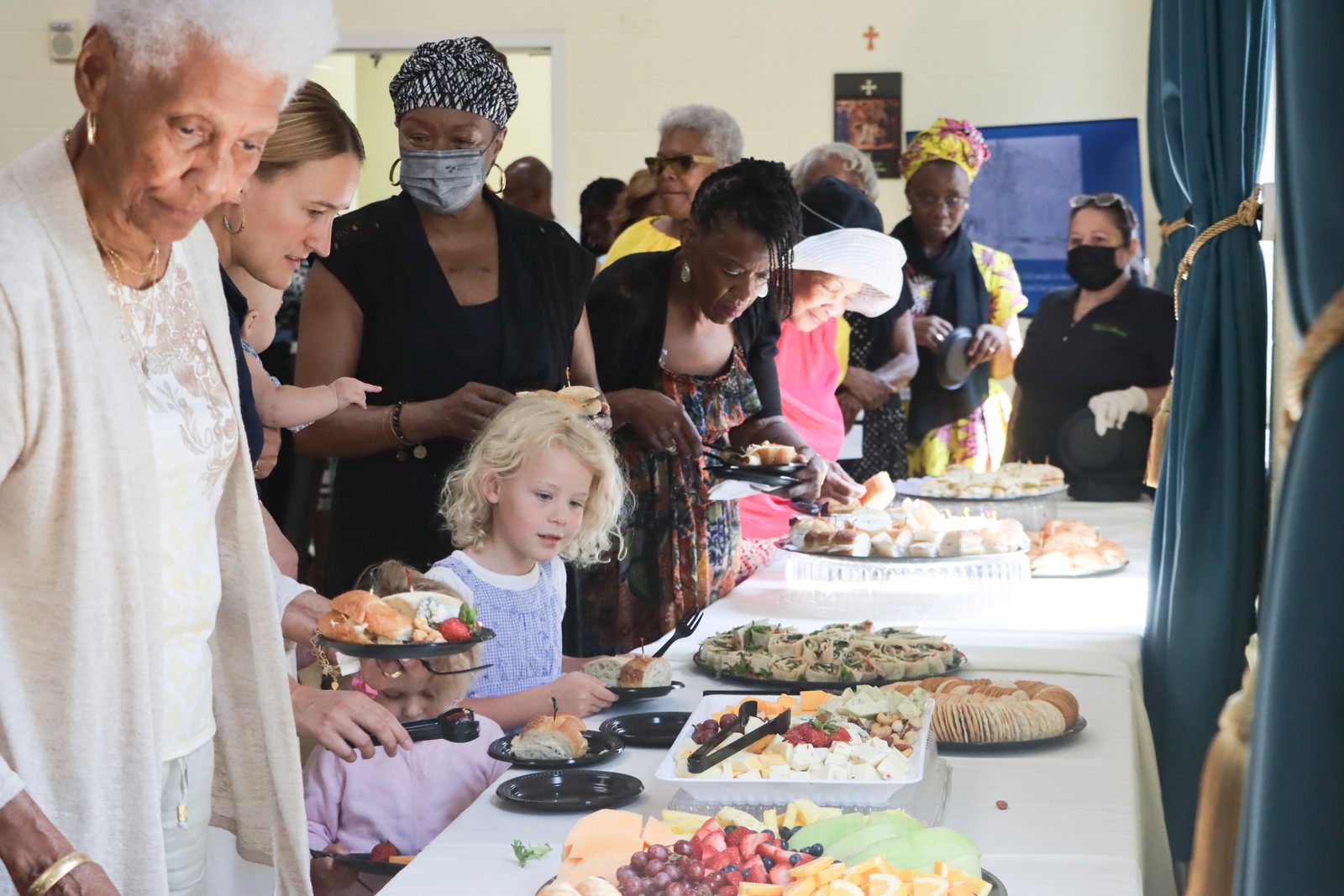People line up for food at a reception that followed a July 28 Mass marking the 175th anniversary of St. Ignatius Church in Oxon Hill. (Catholic Standard photo by Javier Diaz)