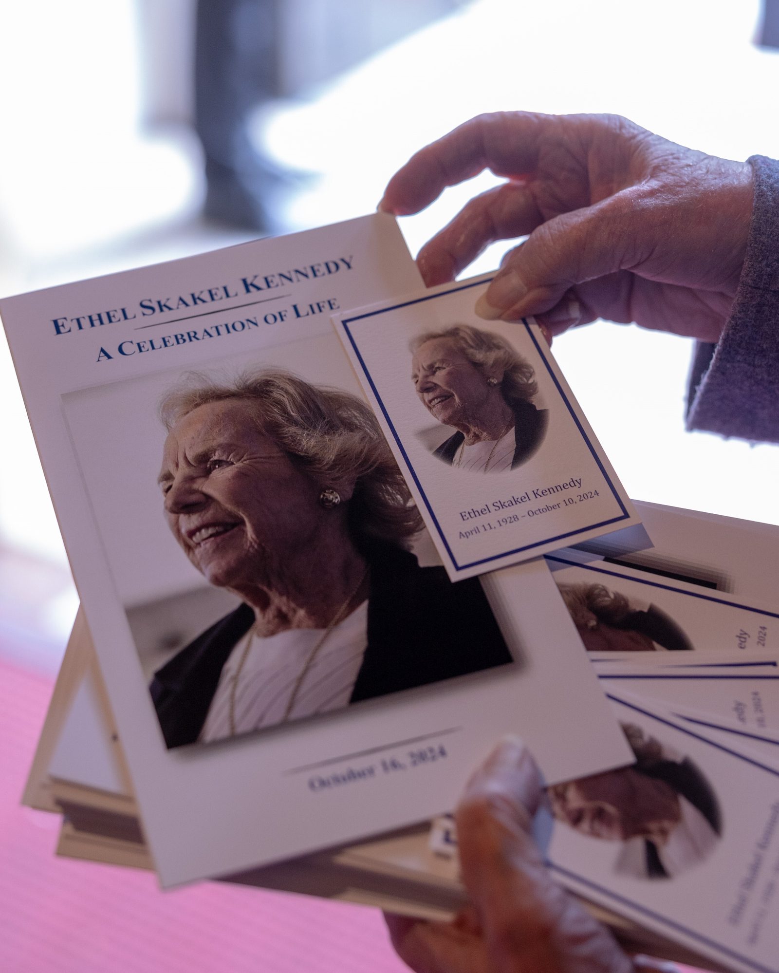 An usher holds programs and memorial cards that were handed out during a celebration of the life of the late Ethel Skakel Kennedy on Oct. 16, 2024 at St. Matthew’s Cathedral in Washington, D.C.. She died on Oct. 10 at the age of 96. (Catholic Standard photo by Mihoko Owada)