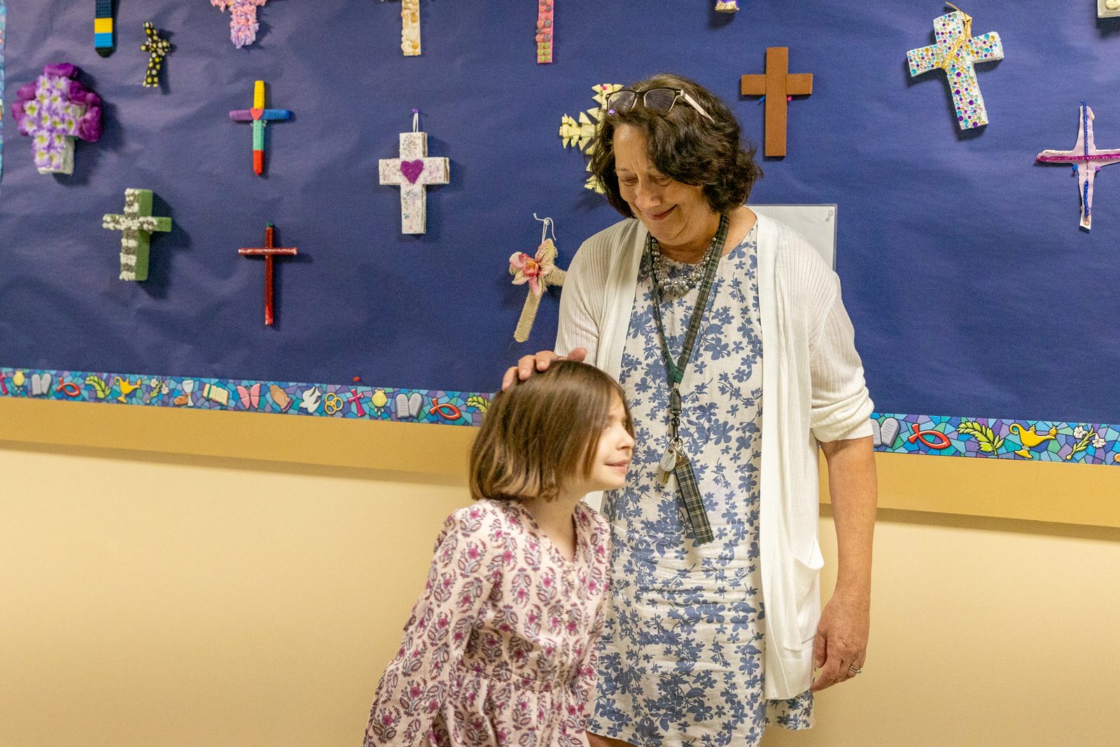 After being announced as a 2024 Golden Apple Award winning teacher on April 17, Michelle Roche, a fourth grade teacher at St. Raphael School in Rockville, Maryland, greets third grader Cora Haffner. (Catholic Standard photo by Mihoko Owada)