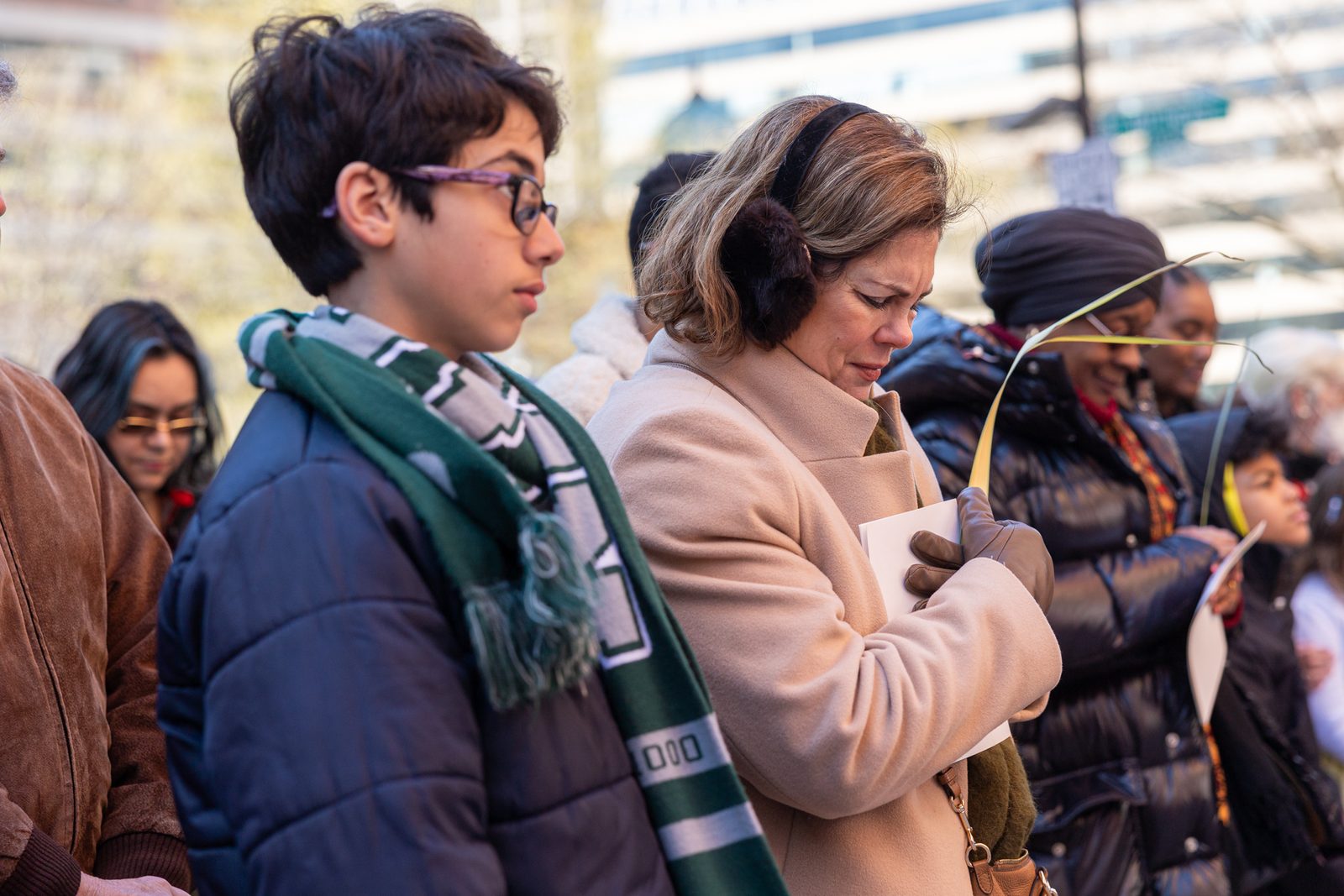 People stand outside the Cathedral of St. Matthew the Apostle in Washington, D.C., holding palms at the beginning of the Palm Sunday of the Lord’s Passion Mass on March 24, 2024 celebrated by Cardinal Wilton Gregory. (Catholic Standard photo by Mihoko Owada)
