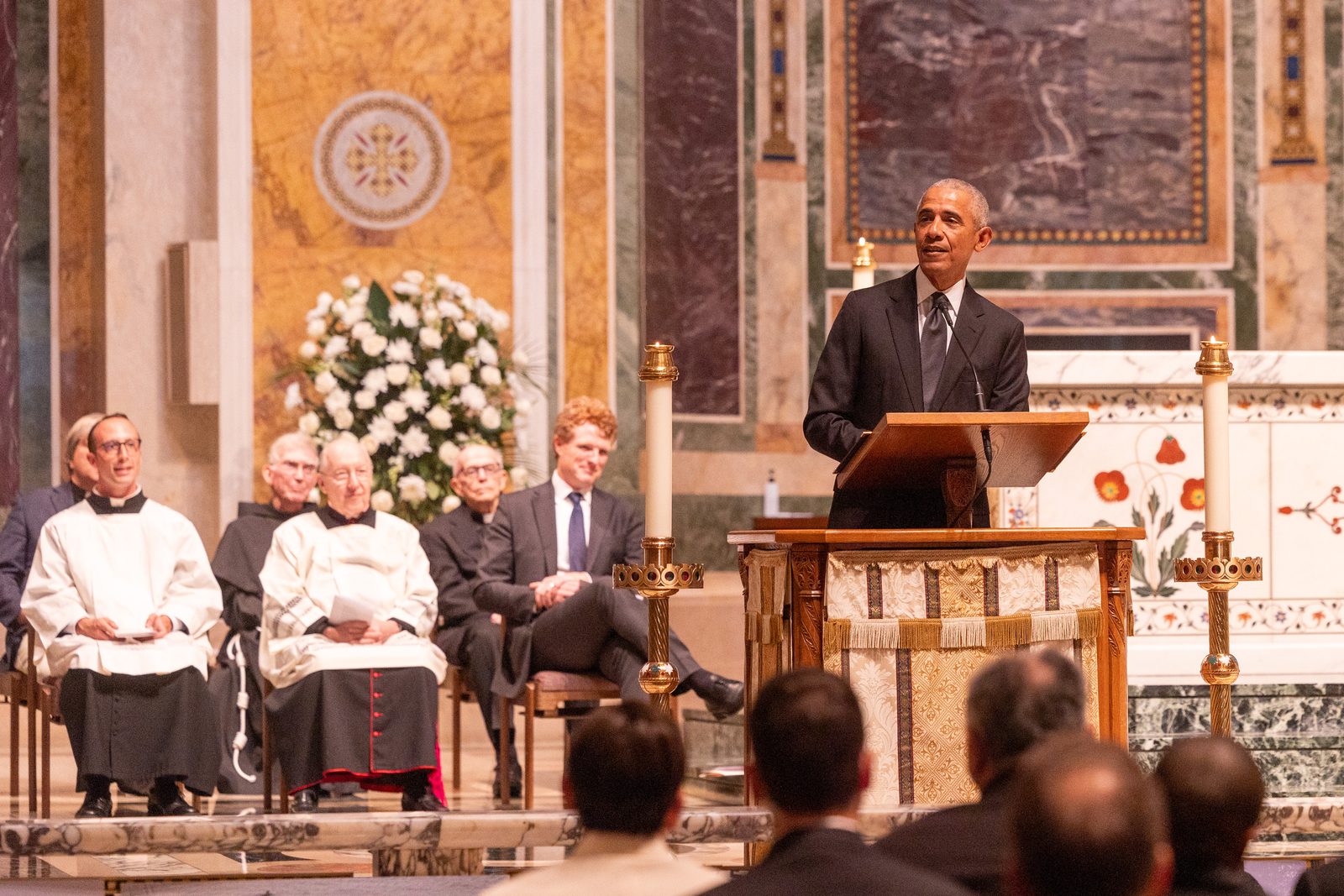 Former President Barack Obama speaks during a celebration of the life of the late Ethel Kennedy held on Oct. 16, 2024 at the Cathedral of St. Matthew the Apostle in Washington, D.C. Seated at left are Father Joseph McHenry, a parochial vicar there; Msgr. W. Ronald Jameson, the cathedral’s rector; and Joseph Kennedy III, a grandson of Ethel Kennedy. (Catholic Standard photo by Mihoko Owada)