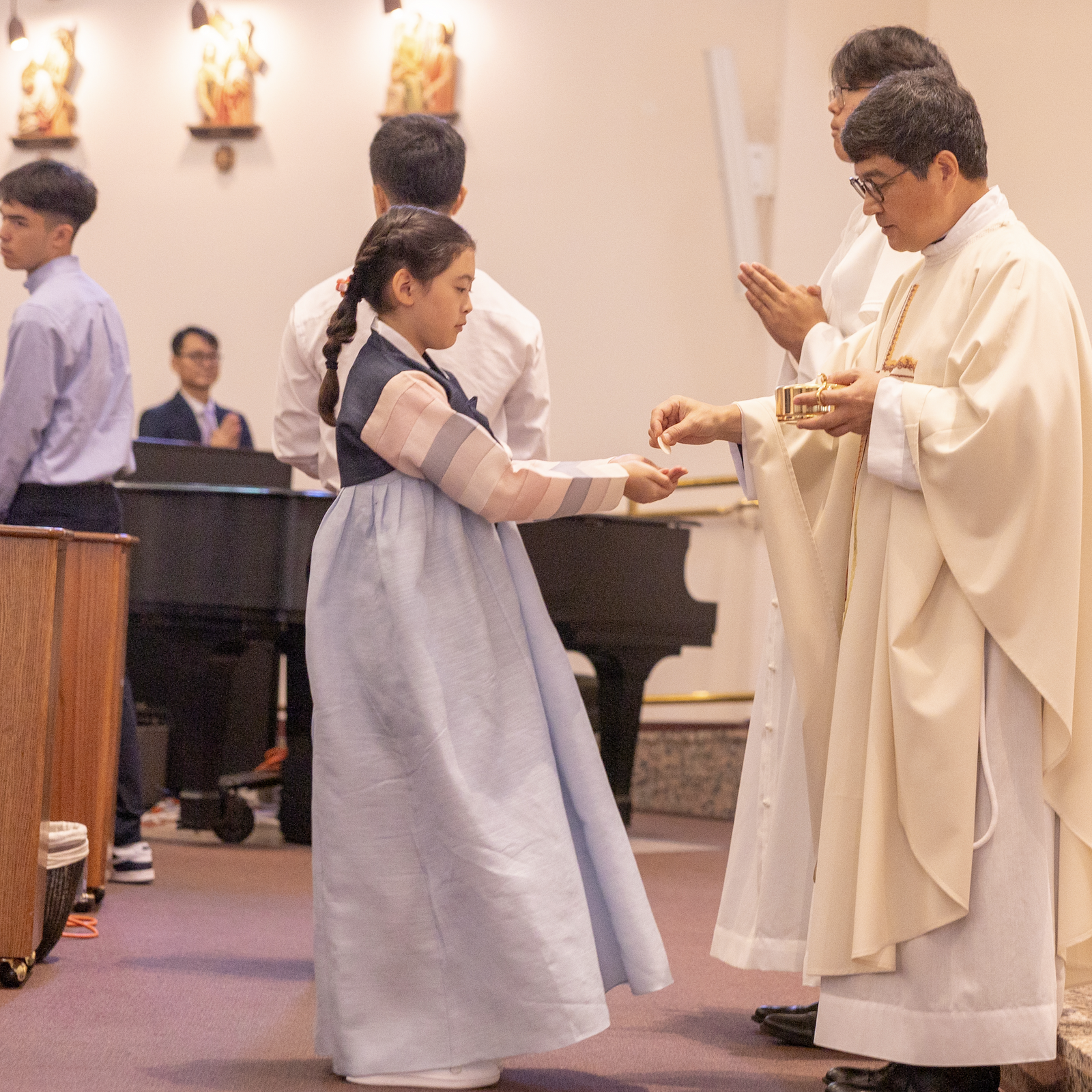 Father Matthew Park, the pastor of St. Andrew Kim Parish in Olney, Maryland, gives Communion to Yuvin Kim during a Sept. 29 Mass marking the Korean parish’s 50th anniversary. Kim, who is 9, read the first Scripture reading at the anniversary Mass. (Catholic Standard photo by Mihoko Owada)