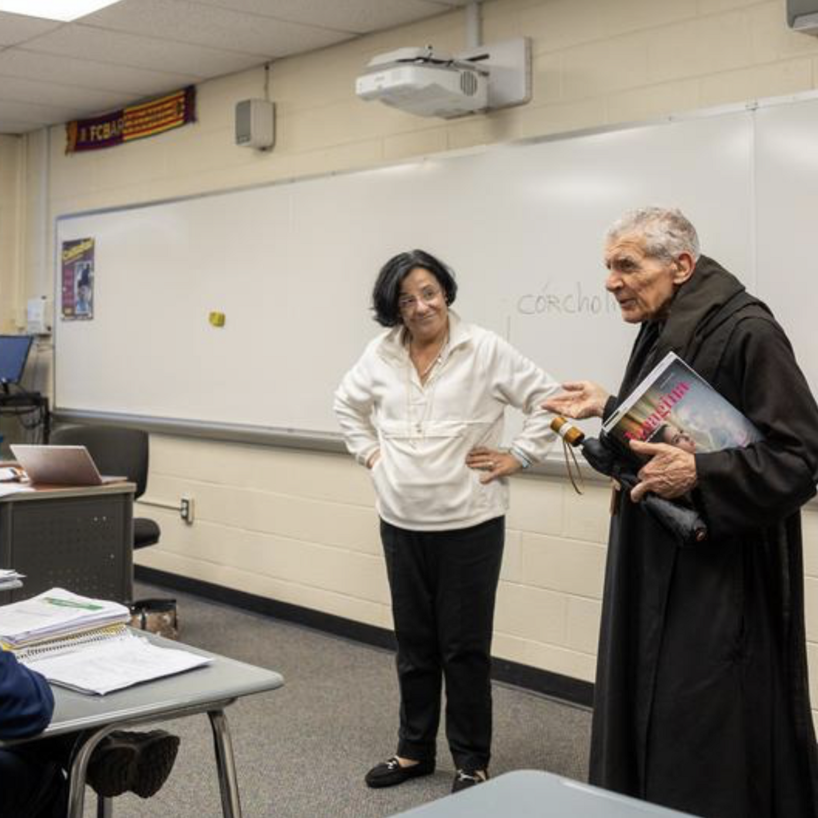 Abbot James Wiseman greets 10th grade students and the teacher, Belen Fernandez at the beginning of the Spanish III language class at St. Anselm's Abbey School in Washington on Dec. 11, 2024. He is taking the Spanish class with the students. (Catholic Standard photo by Mihoko Owada)