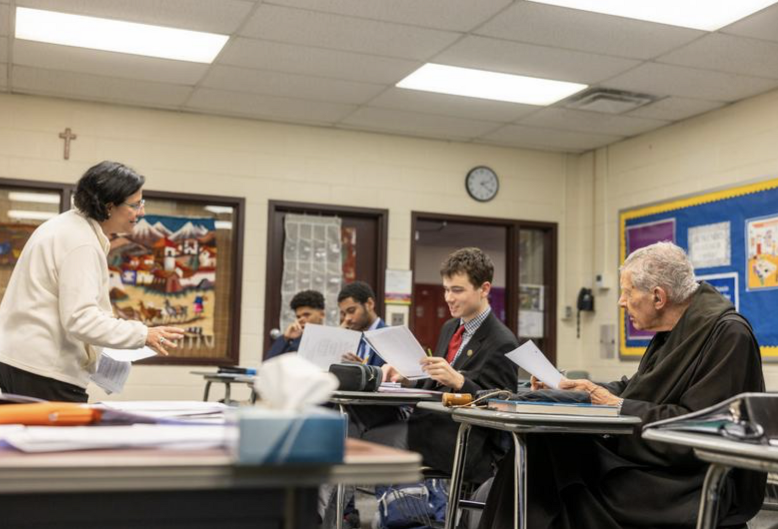 Belen Fernandez teaches a Spanish III language class at St. Anselm’s Abbey School in Washington on Dec. 11, 2024. Abbot James Wiseman of St. Anselm's Abbey (at right) learns with the students. (Catholic Standard photo by Mihoko Owada)