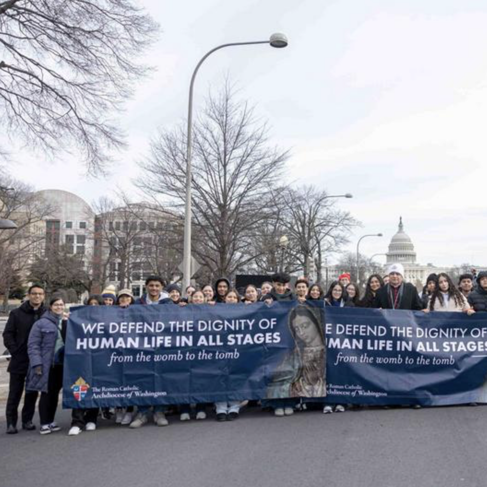 On Pennsylvania Avenue in Washington, D.C., Auxiliary Bishop Evelio Menjivar of Washington stands alongside young people from the Roman Catholic Archdiocese of Washington, D.C., who carried the archdiocese's banners during the March for Life on Jan. 23, 2026. (Catholic Standard photo by Mihoko Owada)
