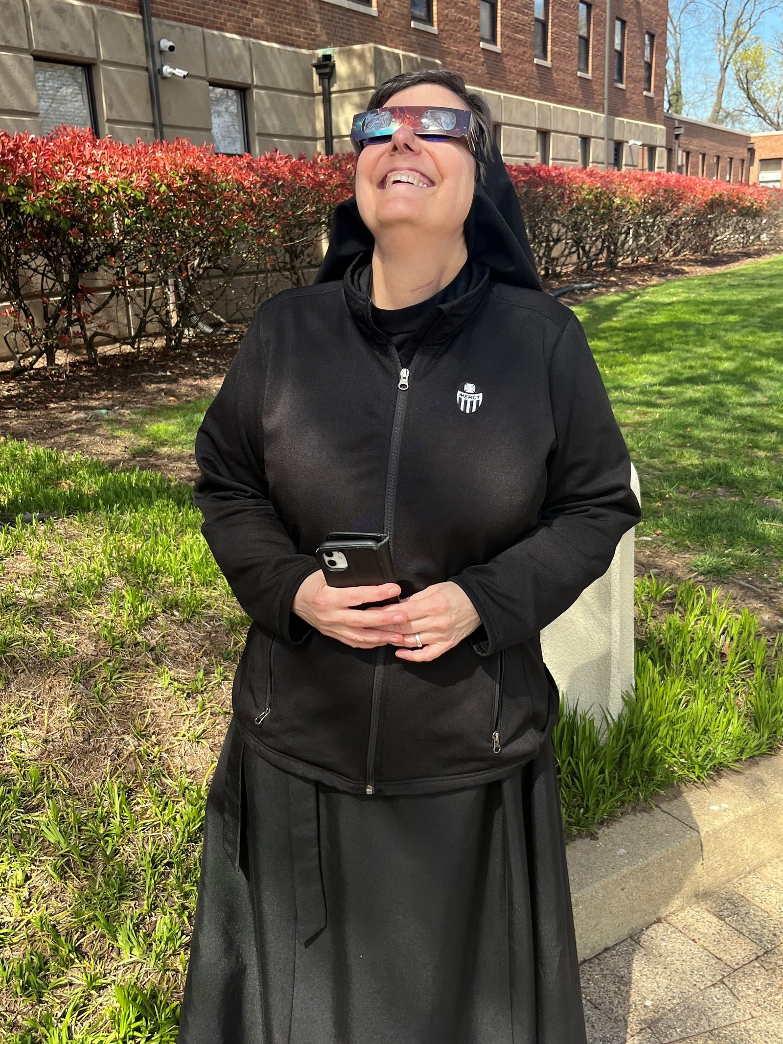 Sister Gilmary Kay, a Religious Sister of Mercy who leads the Office of Consecrated Life for The Roman Catholic Archdiocese of Washington, views the solar eclipse on April 8, 2024 outside the Archdiocesan Pastoral Center in Hyattsville, Maryland. (Catholic Standard photo by Mark Zimmermann)