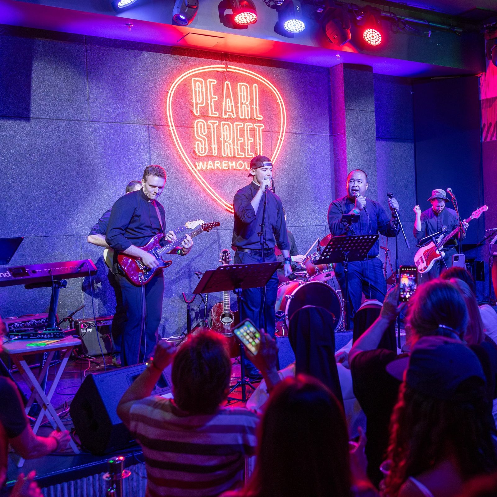 Upon This Rock, a band of local priests, plays during a May 20 concert at the Pearl Street Warehouse in Washington, D.C. From left to right are Father Alexander Wyvill playing the guitar, Father Nicholas Morrison and Father Patrick Agustin singing and Father James Glasgow playing the guitar. Behind them, not visible in the photo, are guitarist Jamie Ascenzo and the band’s drummer, Father Brendan Glasgow. (Catholic Standard photo by Mihoko Owada)