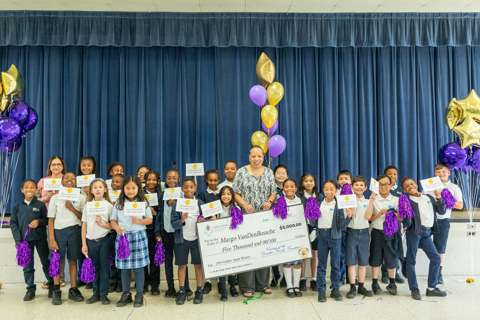 Margo VanDenBossche, profesora del tercer grado de la escuela católica Saint Peter’s School en Waldorf (Maryland), posa al lado de sus estudiantes luego de haber sido premiada con el premio Golden Apple. Foto/Mihoko Owada