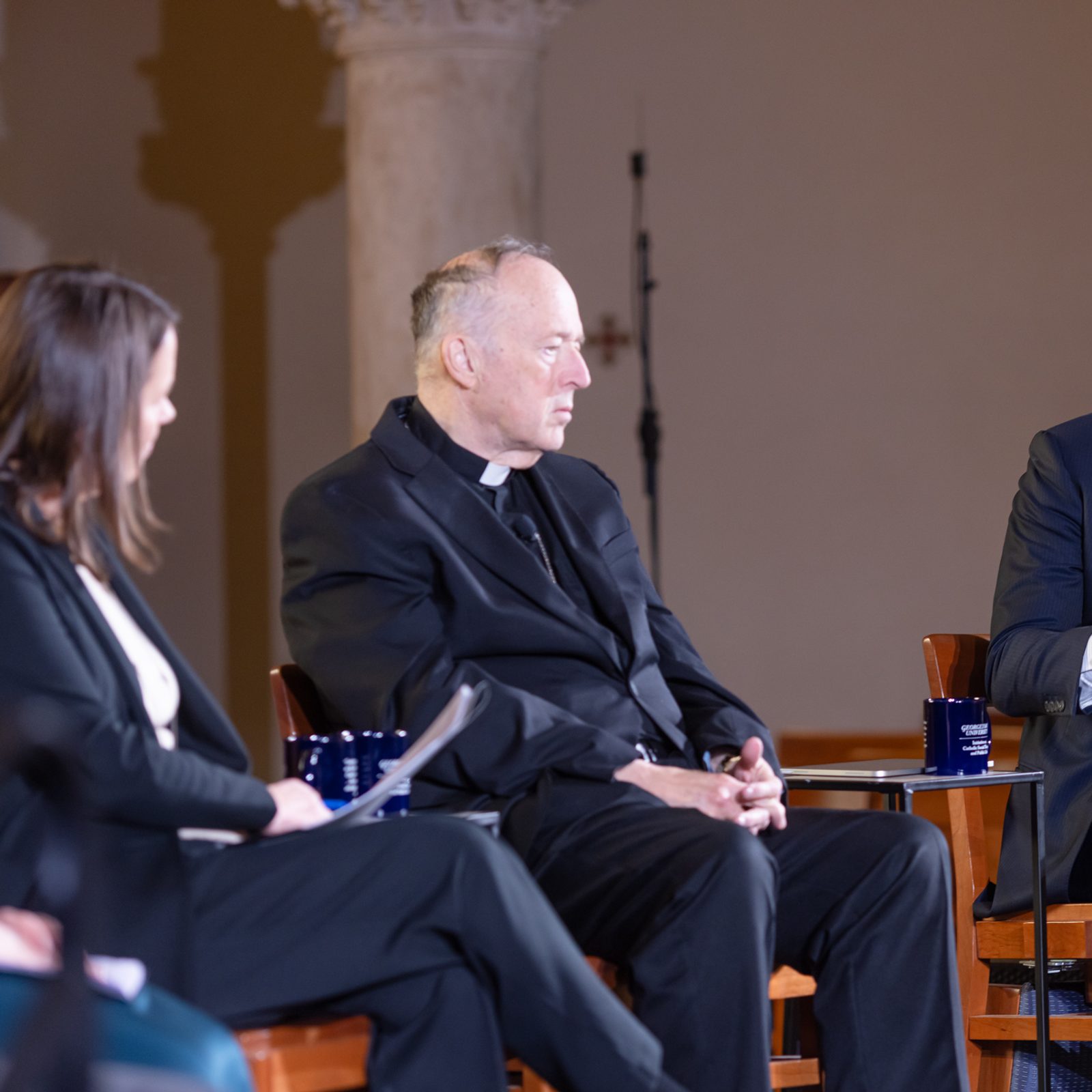 Vincent D. Rougeau (at right), the president of the College of the Holy Cross in Worcester, Massachusetts, speaks during a discussion on “Faith, Democracy, and the Common Good: Lessons from John Courtney Murray for Our Times,” held March 18, 2026 at the Dahlgren Chapel of the Sacred Heart at Georgetown University in Washington, D.C. At left is Kim Daniels, the director of the Initiative on Catholic Social Thought and Public Life at Georgetown, which cosponsors the Dahlgren Dialogues along with the university’s Office of Mission & Ministry, and at center is Washington Cardinal Robert W. McElroy, who also spoke at the event. (Catholic Standard photo by Rachel Lincoln)