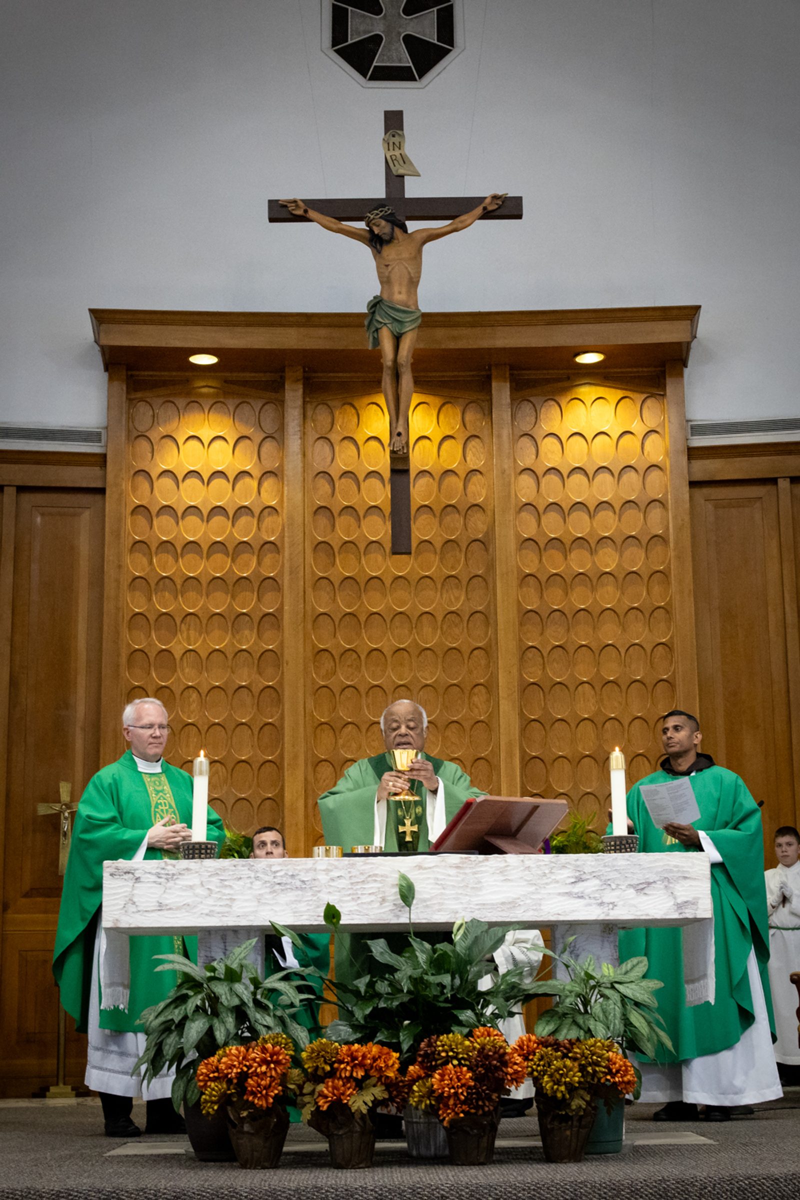 Washington Cardinal Wilton Gregory at center celebrates a Mass on Nov. 10, 2024 at St. John the Baptist Church in Silver Spring, Maryland. The concelebrating priests included Father Andrew Wakefield, at left, the pastor there, and Father Johnson John, CMI, at right, who is a student priest in residence at the parish. At the Mass, Cardinal Gregory blessed the new crucifix and Stations of the Cross in the church. (Catholic Standard photo by Christopher Newkumet)