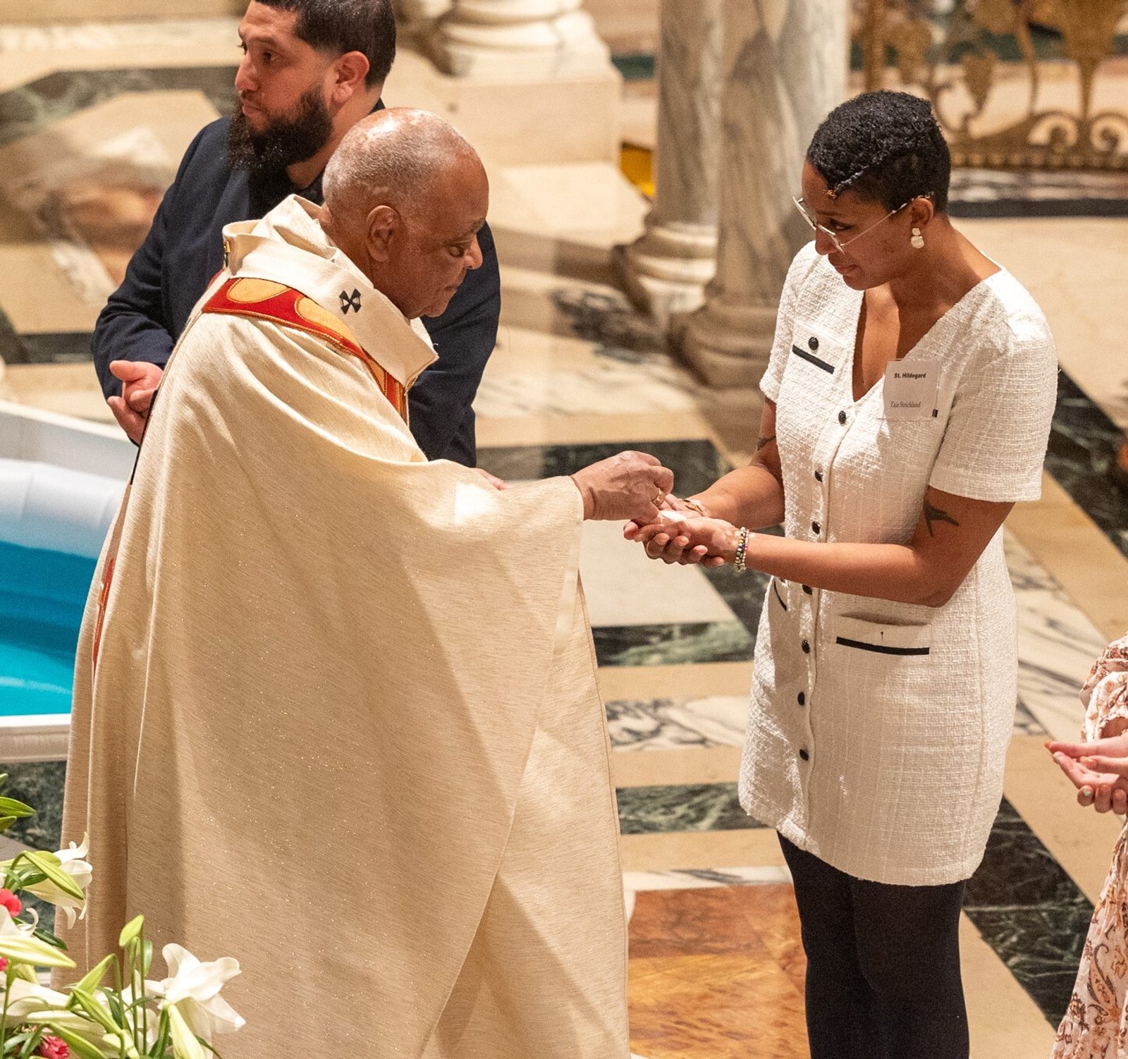 Cardinal Gregory gives the Eucharist to Taja Strickland, a candidate for full communion in the Catholic Church who received that sacrament for the first time at the March 30 Easter Vigil at St. Matthew’s Cathedral in Washington, D.C. (Catholic Standard photo by Mihoko Owada)