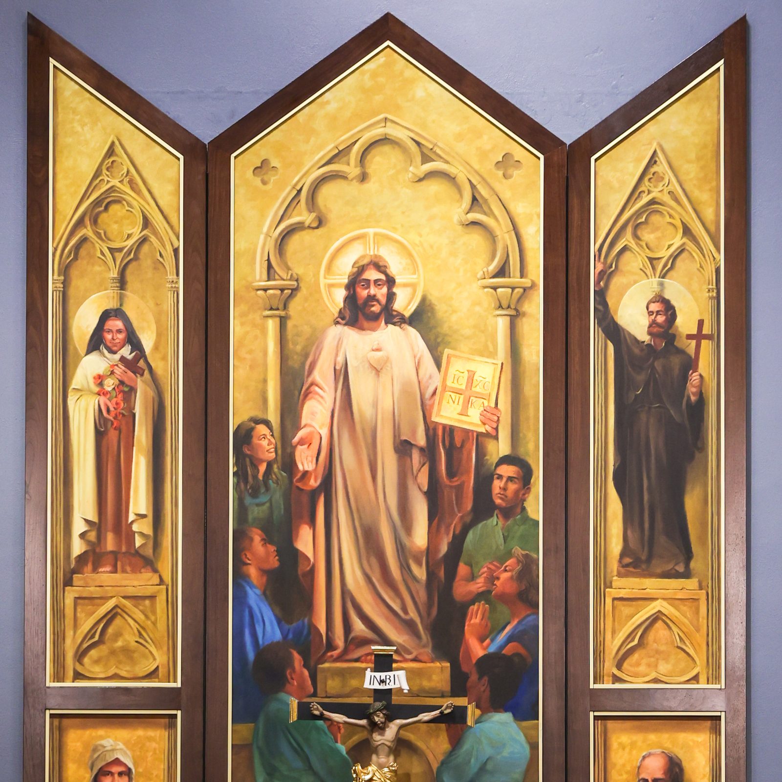 Oil paintings by artist Gordon Daugherty behind the altar of the renovated Chapel of Charity at St. Mary’s Ryken High School in Leonardtown at center depict Christ the teacher, surrounded by the school’s students, teachers and staff. The upper left painting depicts St. Therese of Lisieux, the patron saint of missions, and the upper right painting depicts St. Francis Xavier, another patron saint of missions and the patron saint of the Xaverian order that sponsors the Catholic high school. The lower left painting depicts Mother Catherine Spalding, the foundress of the Sisters of Charity of Nazareth, the order that sponsored St. Mary’s Academy in Leonardtown from 1885 until that school merged with Ryken High School in 1981 to form St. Mary’s Ryken High School. The lower right painting depicts Theodore Ryken, a Dutch Catholic missionary who founded the Xaverian Brothers. (Photo by HD Photography for St. Mary’s Ryken High School)