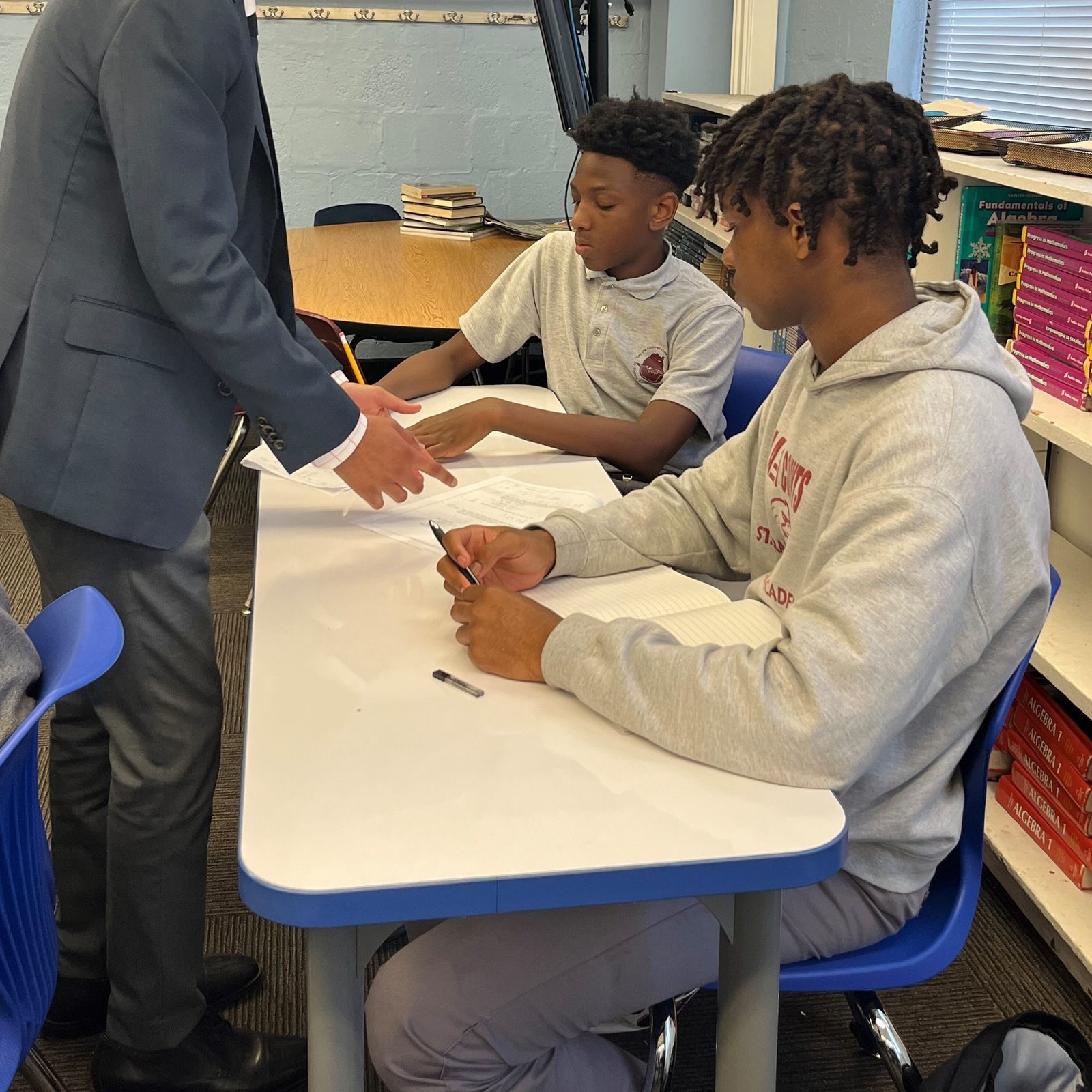 In a photo from May 2024, Zayd Patel, now a senior at The Heights School in Potomac, Maryland, assists Luke Roberts and J'Mir Freeman, who were then seventh graders, during an after-school math program at St. Francis Xavier Catholic Academy in Washington. (Catholic Standard photo by Mark Zimmermann)