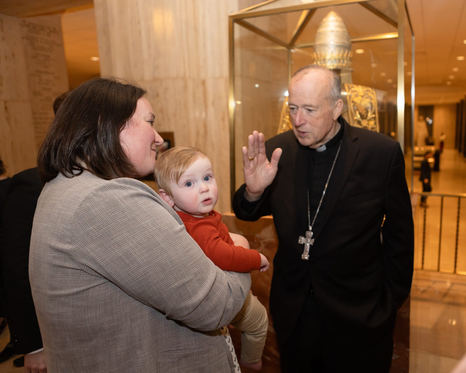 After being installed as Washington’s new archbishop on March 11, 2025 at the Basilica of the National Shrine of the Immaculate Conception, Cardinal Robert McElroy blesses a child. Cardinal McElroy greeted members of the Archdiocese of Washington and other guests in the basilica’s lower level. (Catholic Standard photo by Rachel Lincoln)