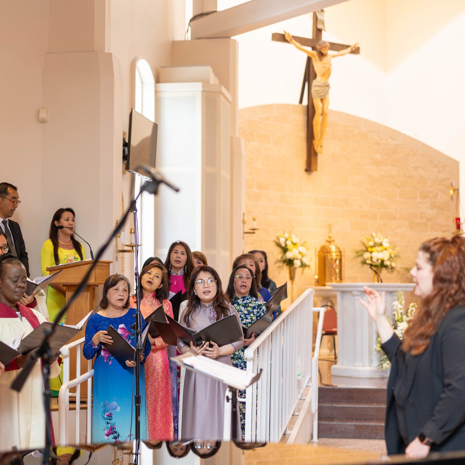 Members of the Vietnamese choir at Mother Seton Parish in Germantown join the parish’s choir in singing a prelude before a Mass on June 30, 2024 celebrated by Cardinal Wilton Gregory that marked the Maryland parish’s 50th anniversary. In the photo below, members of the Vietnamese choir pray during the anniversary Mass. (Catholic Standard photos by Mihoko Owada)