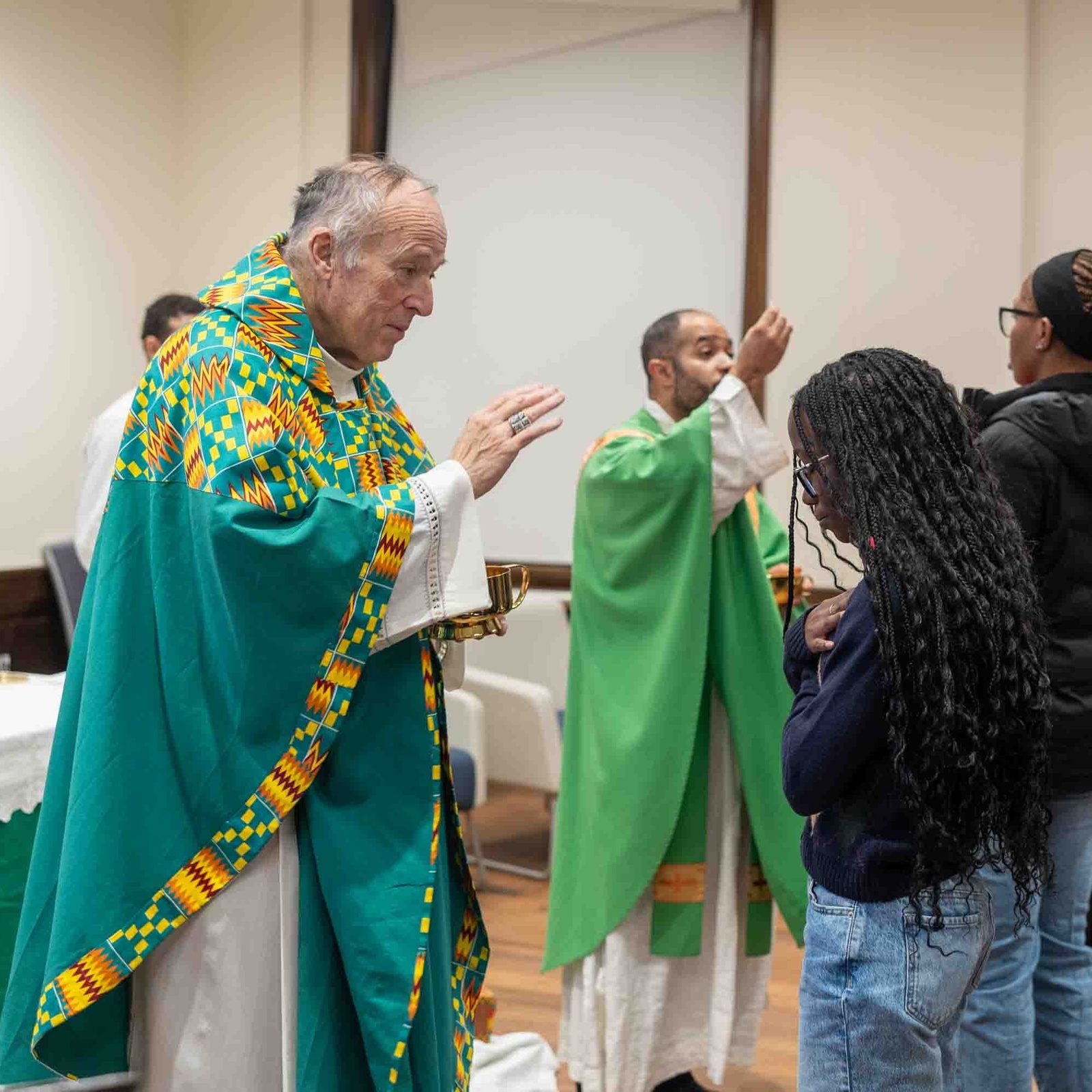Washington Cardinal Robert W. McElroy blesses a student during Communion at a Feb. 1 Mass that he celebrated at Howard University. Distributing Communion at right is Father Robert Boxie III, who serves as the Catholic chaplain at the university. (Catholic Standard photo by Mihoko Owada)