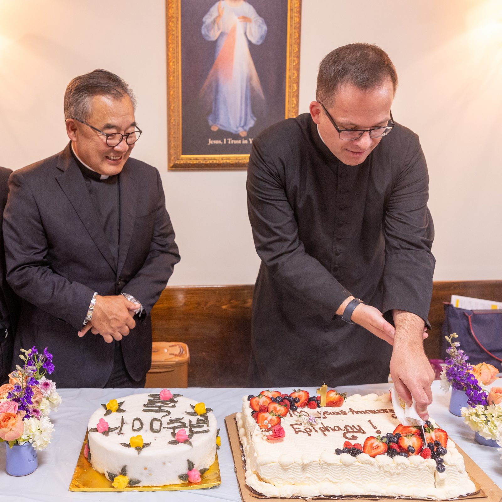 Father Stefan Megyery (at right), the pastor of Epiphany Parish in Washington, D.C., cuts a cake at a luncheon on May 18, 2025 celebrating the parish’s 100th anniversary. Joining him are Father Adam Park (at left) and Father Paul Lee (at center), former pastors of the parish who were among the concelebrants at the anniversary Mass at Epiphany Catholic Church that preceded the luncheon. (Catholic Standard photo by Mihoko Owada)