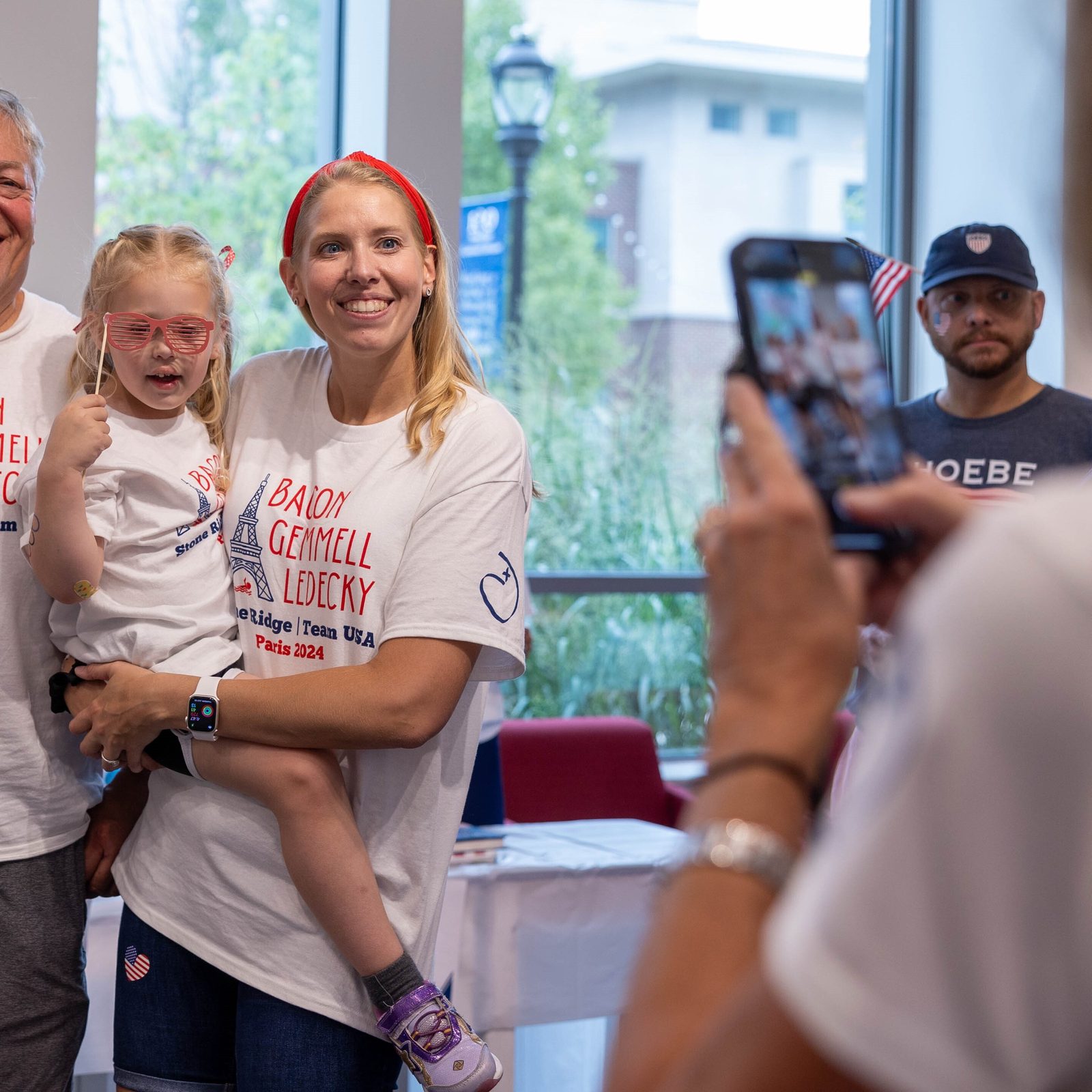 Family members pose for a photo before a July 25 pep rally at Stone Ridge School of the Sacred Heart in Bethesda celebrating three of the school’s graduates – Katie Ledecky (class of 2015), Phoebe Bacon (class of 2020) and Erin Gemmell (class of 2023) – who are members of the U.S. Olympic Swimming Team competing in the Summer Olympics in Paris. (Catholic Standard photo by Mihoko Owada)