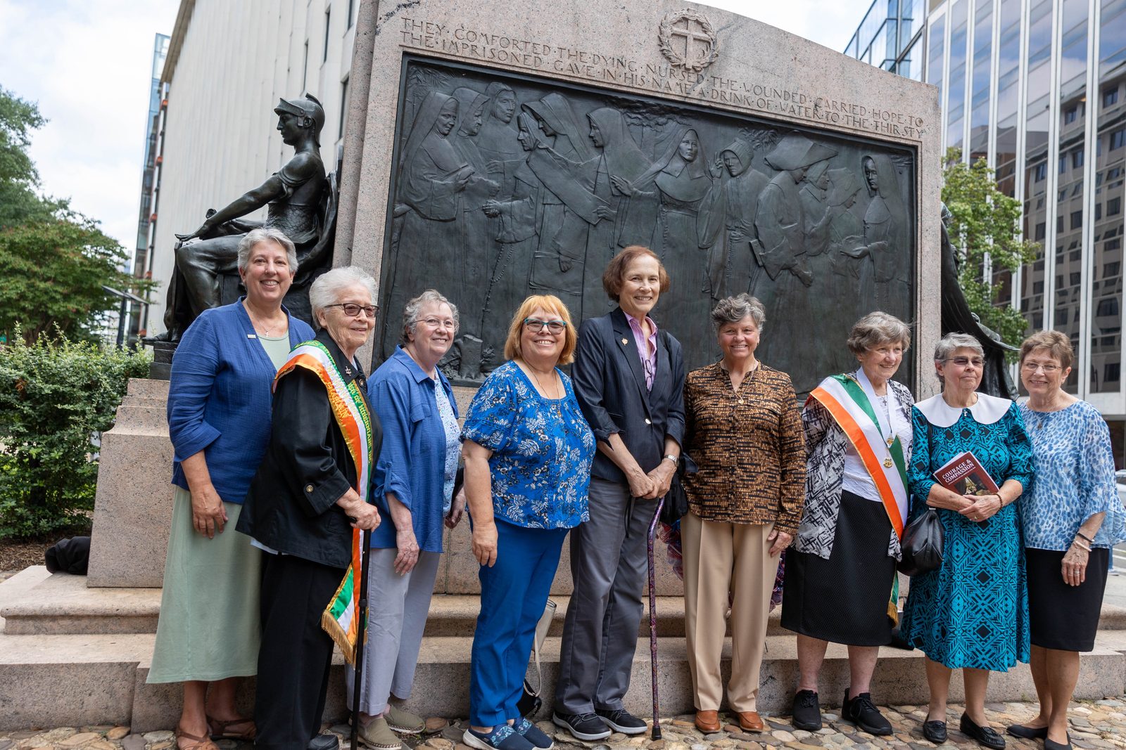 Women religious pose for a photo at the Nuns of the Battlefield Monument across the street from the Cathedral of St. Matthew the Apostle in downtown Washington, D.C., on Sept. 21, 2024, following a Mass celebrated by Cardinal Wilton Gregory marking the 100th anniversary of the 1924 dedication of the monument. After the Mass, Cardinal Gregory offered prayers rededicating the monument, and then a ceremony was held where a new wayside marker offering an overview of the monument was dedicated. The Ladies Ancient Order of Hibernians led the drive to establish the monument 100 years ago, and also led the effort to erect the wayside marker to mark the monument’s centennial. (Catholic Standard photo by Mihoko Owada)