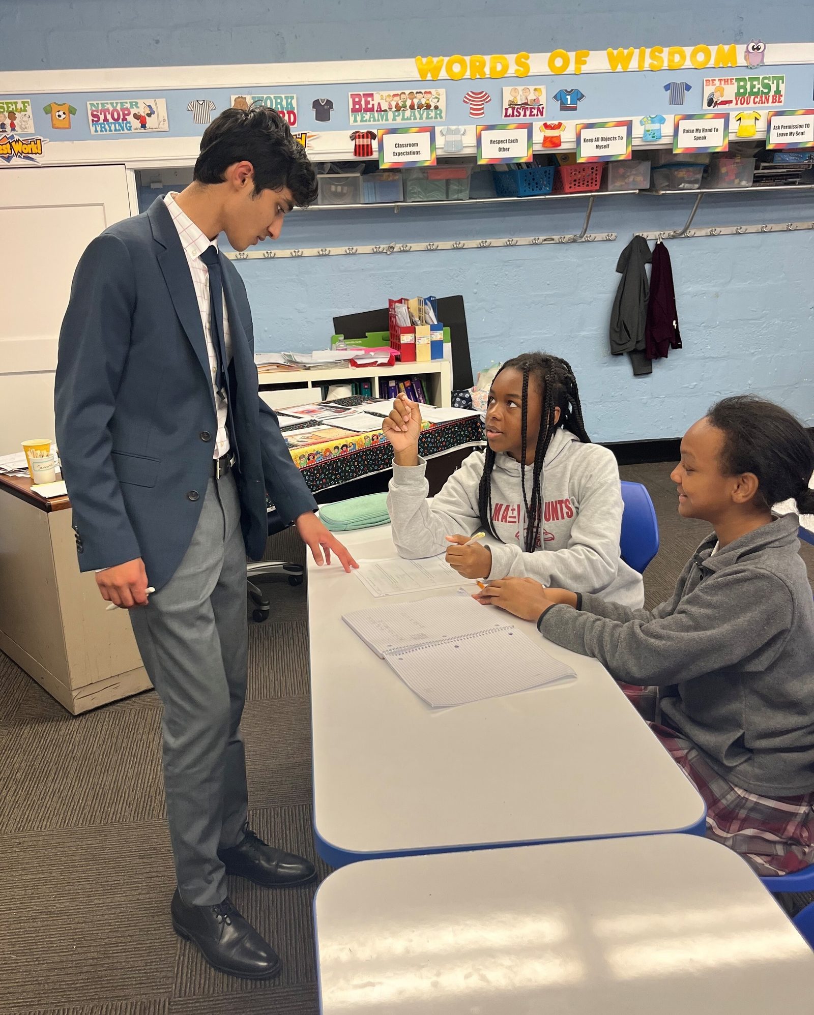 In a photo from May 2024, Zayd Patel, now a senior at The Heights School in Potomac, Maryland – teaches math to middle school students at St. Francis Xavier Catholic Academy in Washington, including Coriana Dobson, then a seventh grader, and Penelope Hawkins, then a sixth grader. (Catholic Standard photo by Mark Zimmermann)