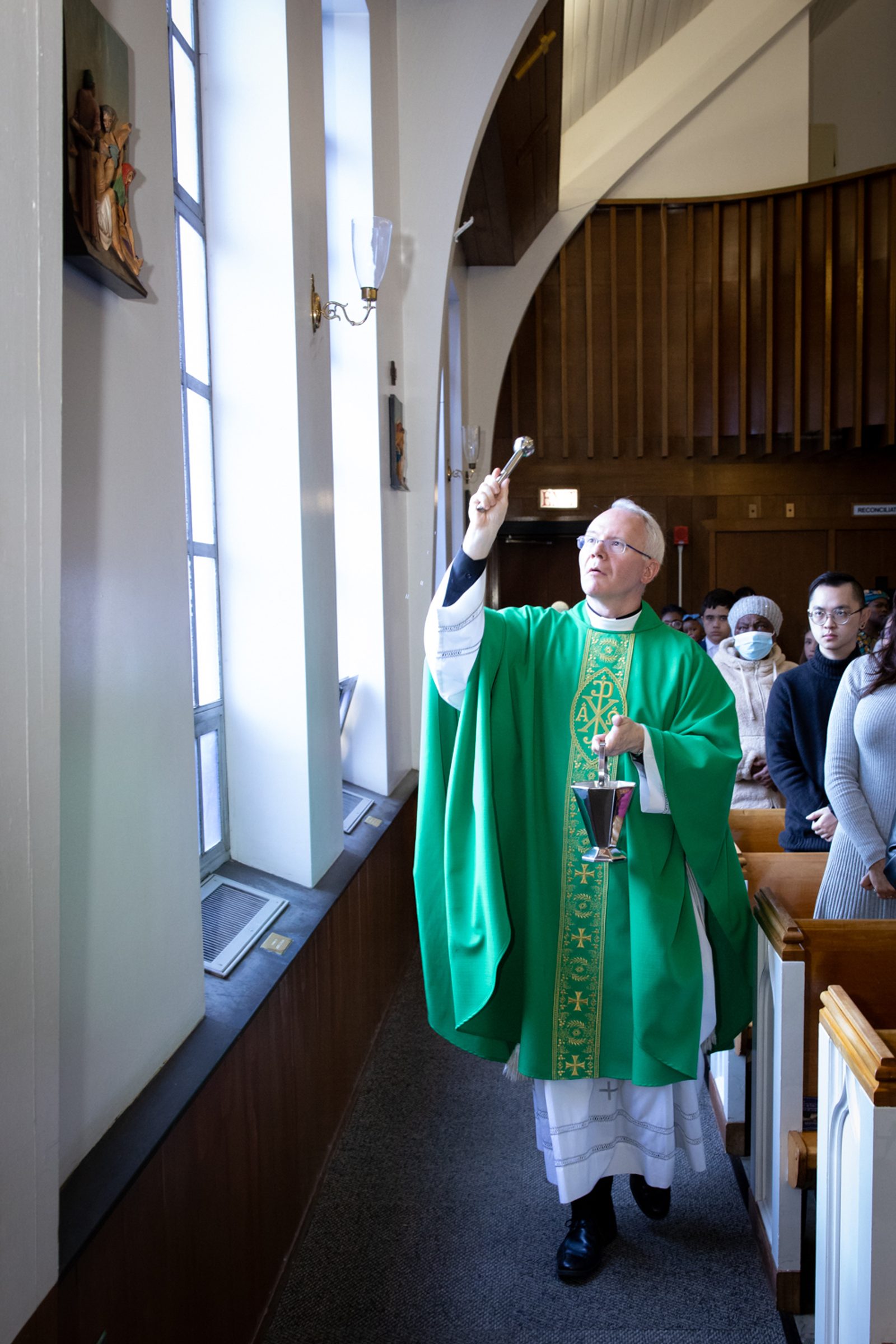 During a Mass on Nov. 10 at St. John the Baptist Church in Silver Spring, Father Andrew Wakefield, the pastor there, sprinkles holy water on the new Stations of the Cross. (Catholic Standard photo by Christopher Newkumet)