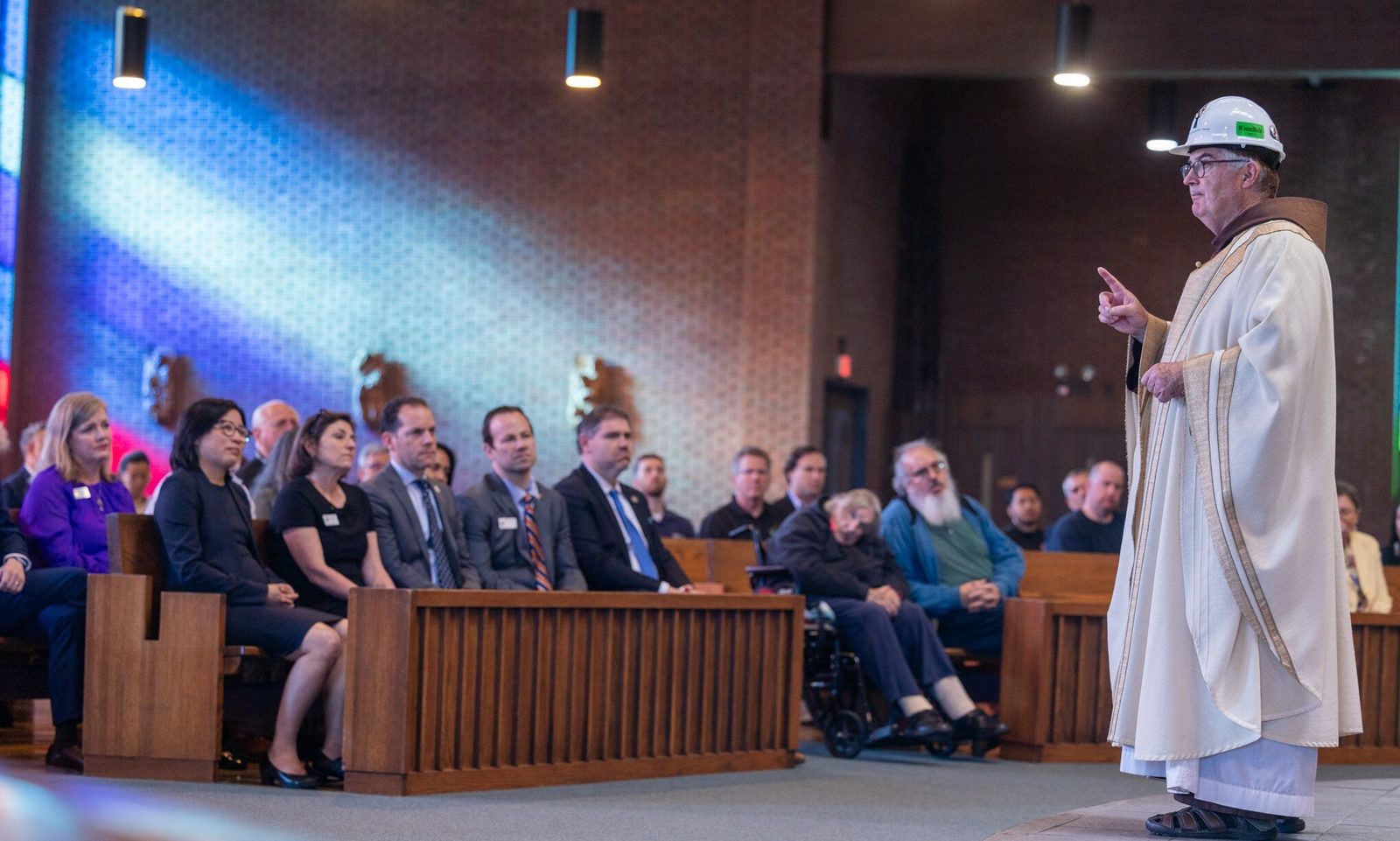 Wearing a hard hat with a cross on it, Franciscan Father Brian Jordan, the pastor of St. Camillus Church in Silver Spring, Maryland, gives his homily during the Building Trades’ Workers Memorial Mass on April 25 at the church. (Catholic Standard photo by Mihoko Owada)