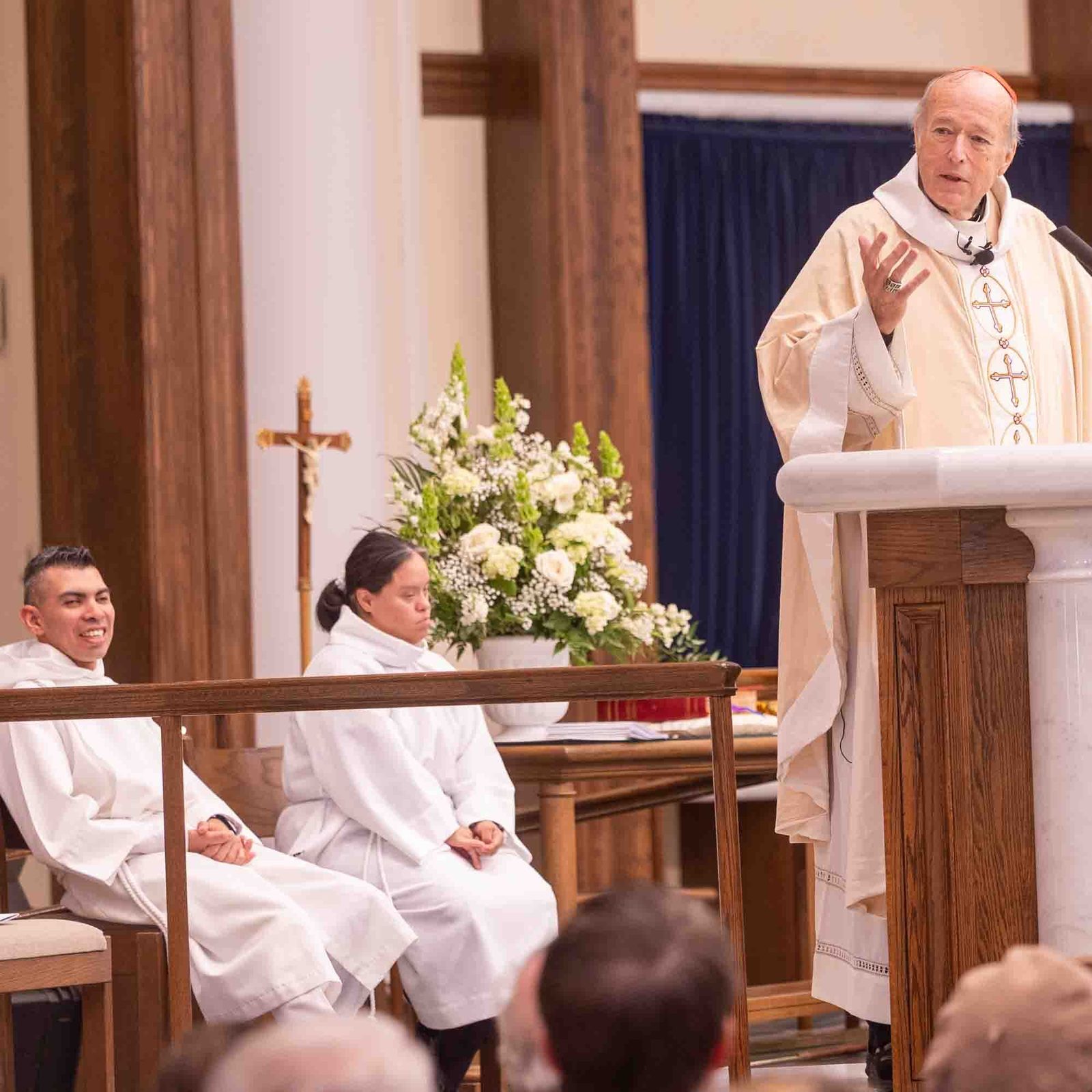 Cardinal Robert W. McElroy gives the homily at the Archdiocese of Washington’s annual White Mass on Oct. 26 at Our Lady of Mercy Church in Potomac. The Mass celebrates the giftedness and the full participation in the Church of people from the Deaf community and persons and their families living with disabilities. Seated at left are altar servers Willie Caro and Maria Guadalupe. (Catholic Standard photo by Mihoko Owada)