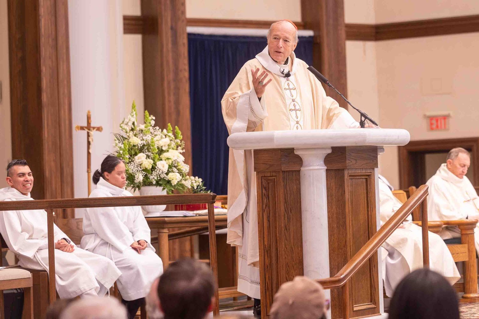 Cardinal Robert W. McElroy gives the homily at the Archdiocese of Washington’s annual White Mass on Oct. 26 at Our Lady of Mercy Church in Potomac. The Mass celebrates the giftedness and the full participation in the Church of people from the Deaf community and persons and their families living with disabilities. Seated at left are altar servers Willie Caro and Maria Guadalupe. (Catholic Standard photo by Mihoko Owada)