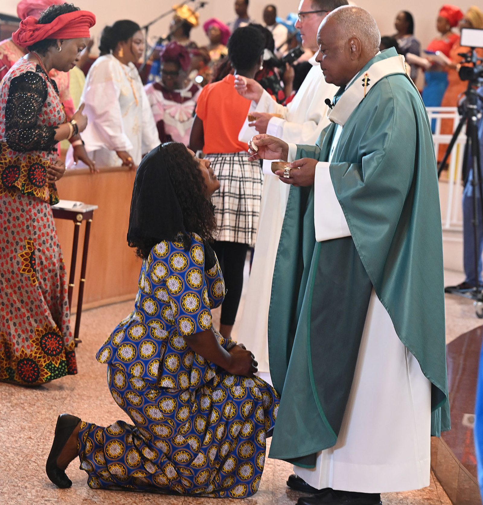 A woman receives Communion from Cardinal Gregory during the Aug. 20 Africa Day Mass at Mother Seton Church in Germantown. (Catholic Standard photo by Leslie Kossoff)