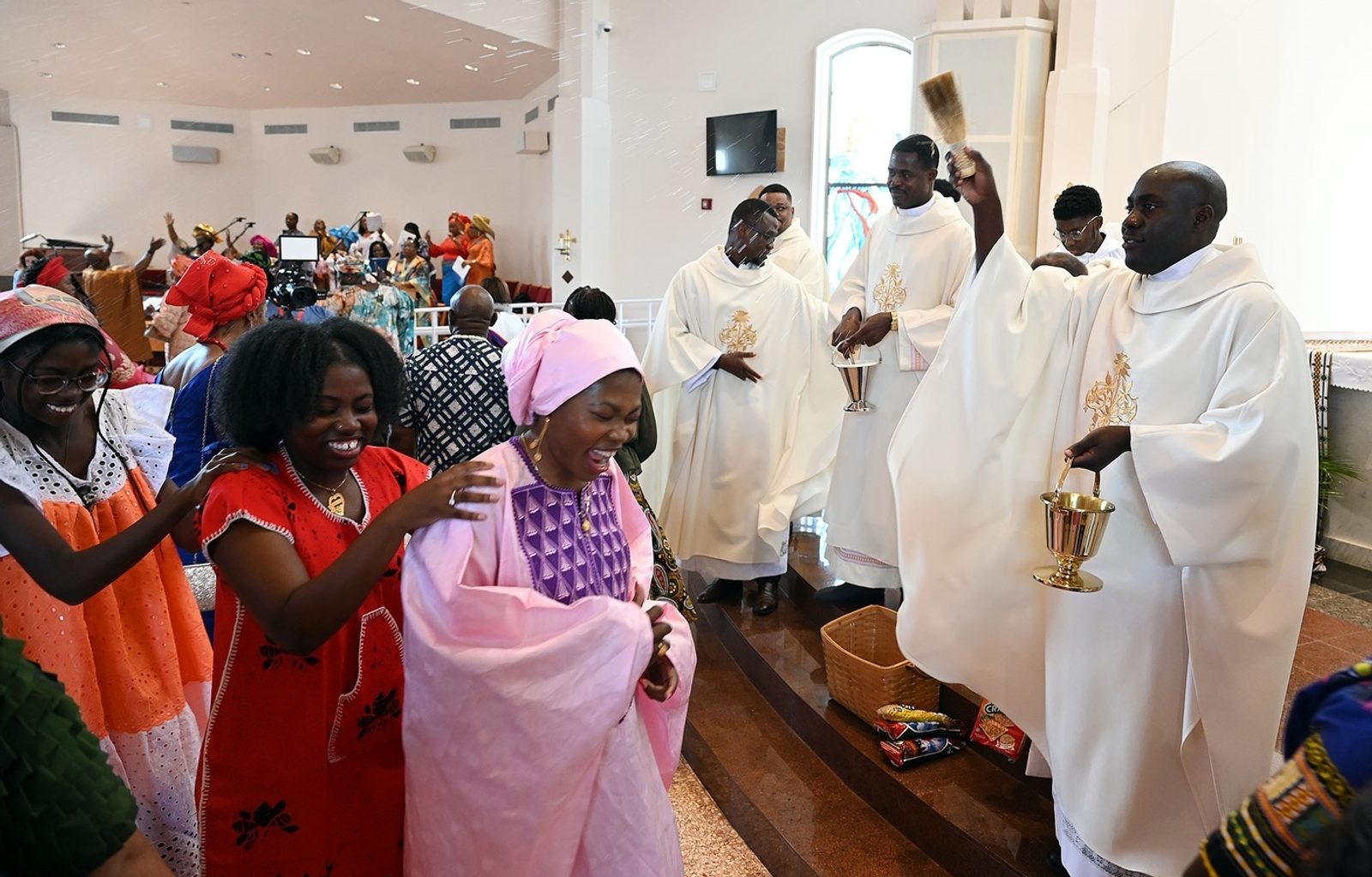 During the Aug. 20 Africa Day Mass at Mother Seton Church in Germantown, African Catholics join a thanksgiving procession to the altar, where priests sprinkled them with holy water. (Catholic Standard photo by Leslie Kossoff)