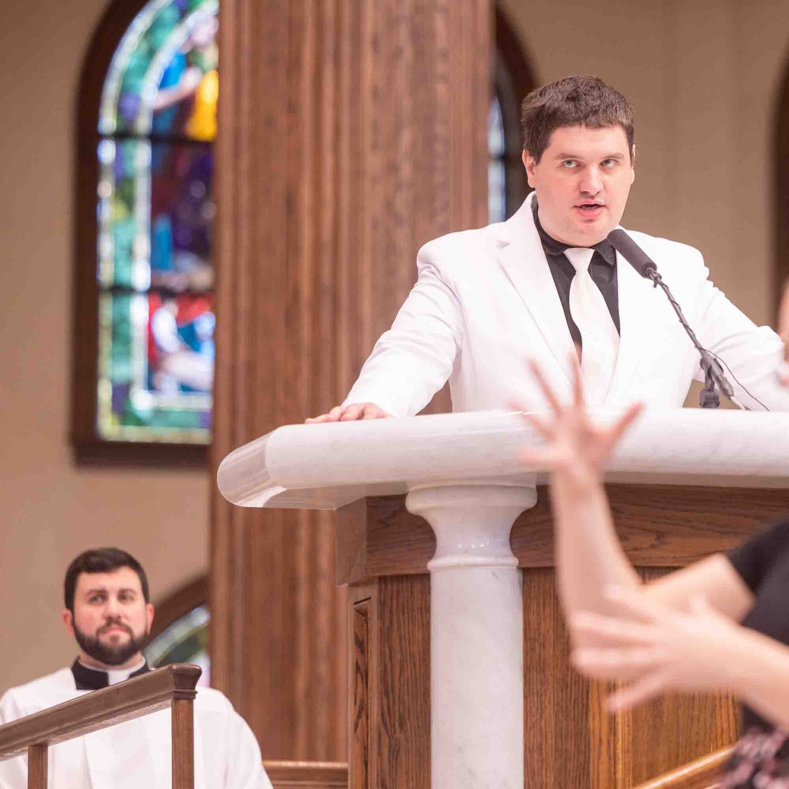 Timmy Menard of St. Aloysius Parish in Leonardtown serves as a cantor during the White Mass on Oct. 26 at Our Lady of Mercy Church in Potomac. In the foreground, Erin Schneider serves as an American Sign Language interpreter during the Mass. (Catholic Standard photo by Mihoko Owada)