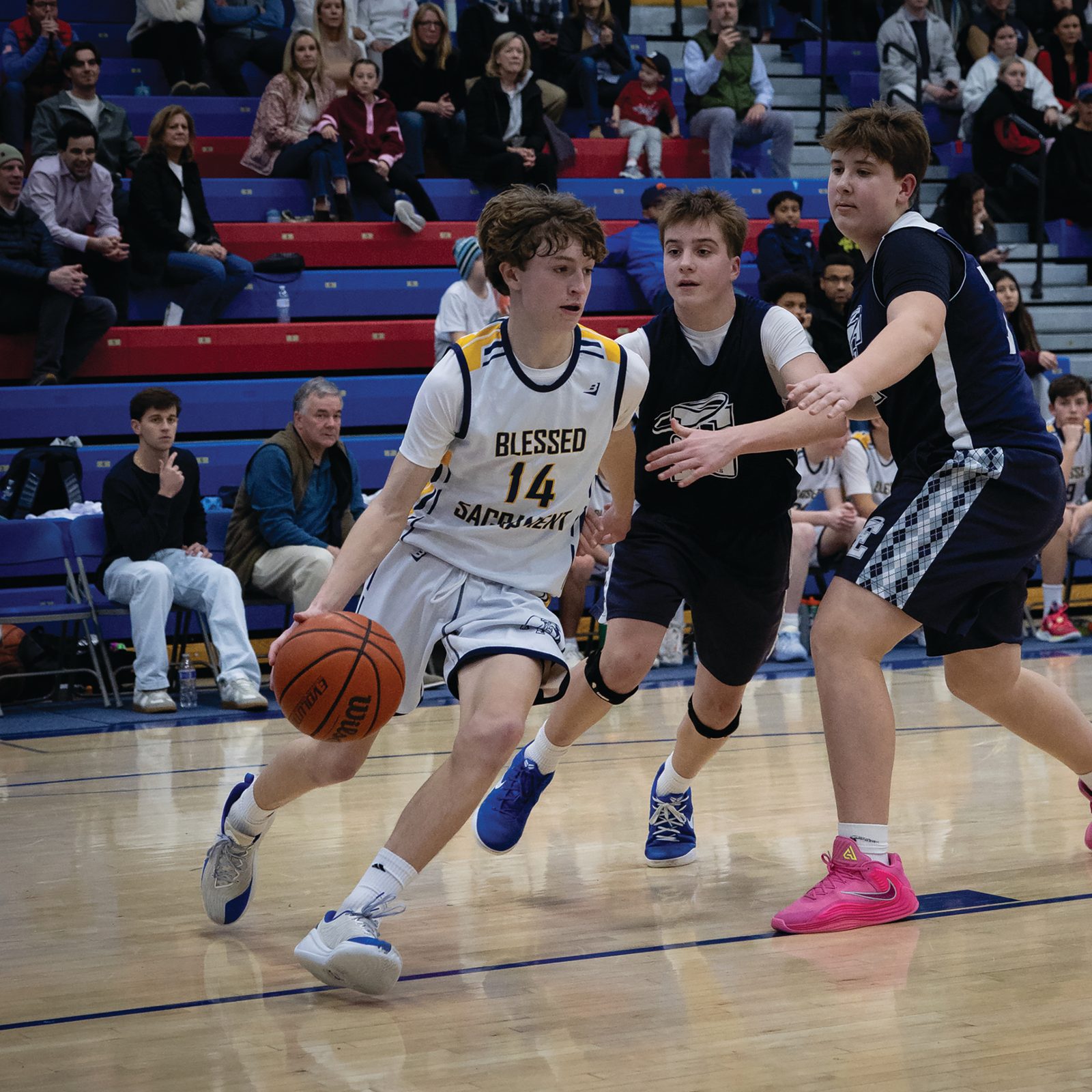 Harrison Inge (#14) of Blessed Sacrament drives down the court while being defended by Connor McCullough and Luke Brzezinski from St. Elizabeth’s of Rockville during the boys’ basketball CYO 14U championship game on Feb. 17 at DeMatha Catholic High School in Hyattsville. The team from Blessed Sacrament Parish in Washington defeated St. Elizabeth’s, 49-36. (Catholic Standard photo by Christopher Newkumet)
