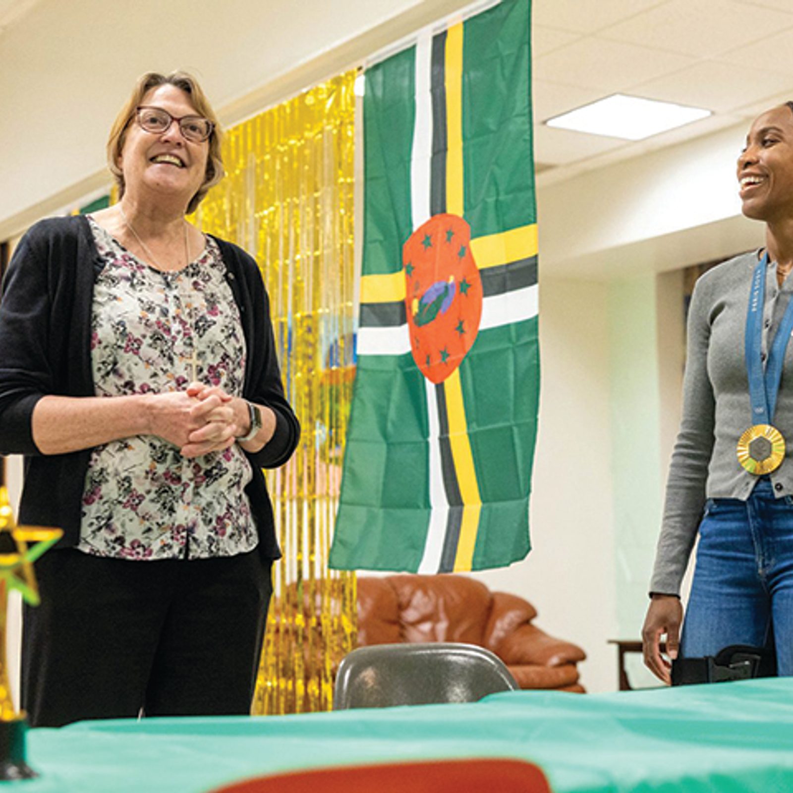 Sister Nancy Downing, CEO of St. Ann’s Center, welcomes Olympic champion Thea LaFond-Gadson (right) to a September 2024 pizza party at the center for mothers and their children living at St. Ann’s. LaFond-Gadson won a gold medal in the women’s triple jump competition at the 2024 Summer Olympics in Paris. (Catholic Standard photo by Mihoko Owada)