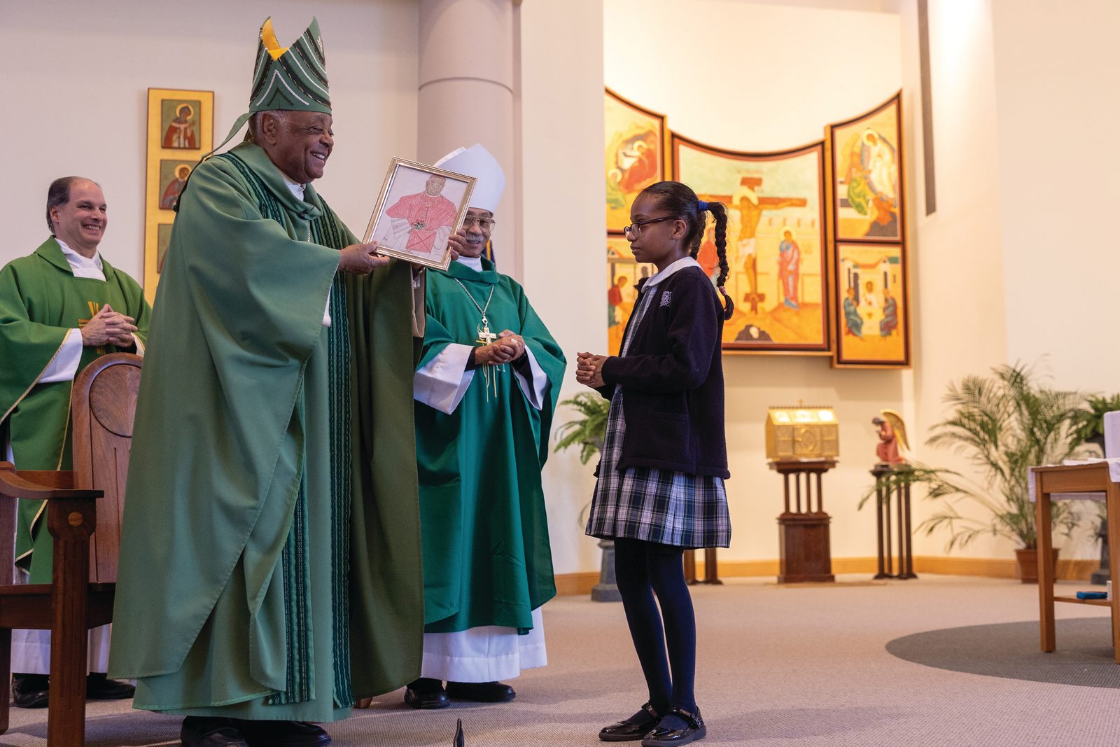 Fourth-grader Oyinkansola Amole presents Cardinal Gregory with a portrait of him that she drew. Admiring the artwork, the cardinal said, “She made me look good.” (Catholic Standard photo by Mihoko Owada)
