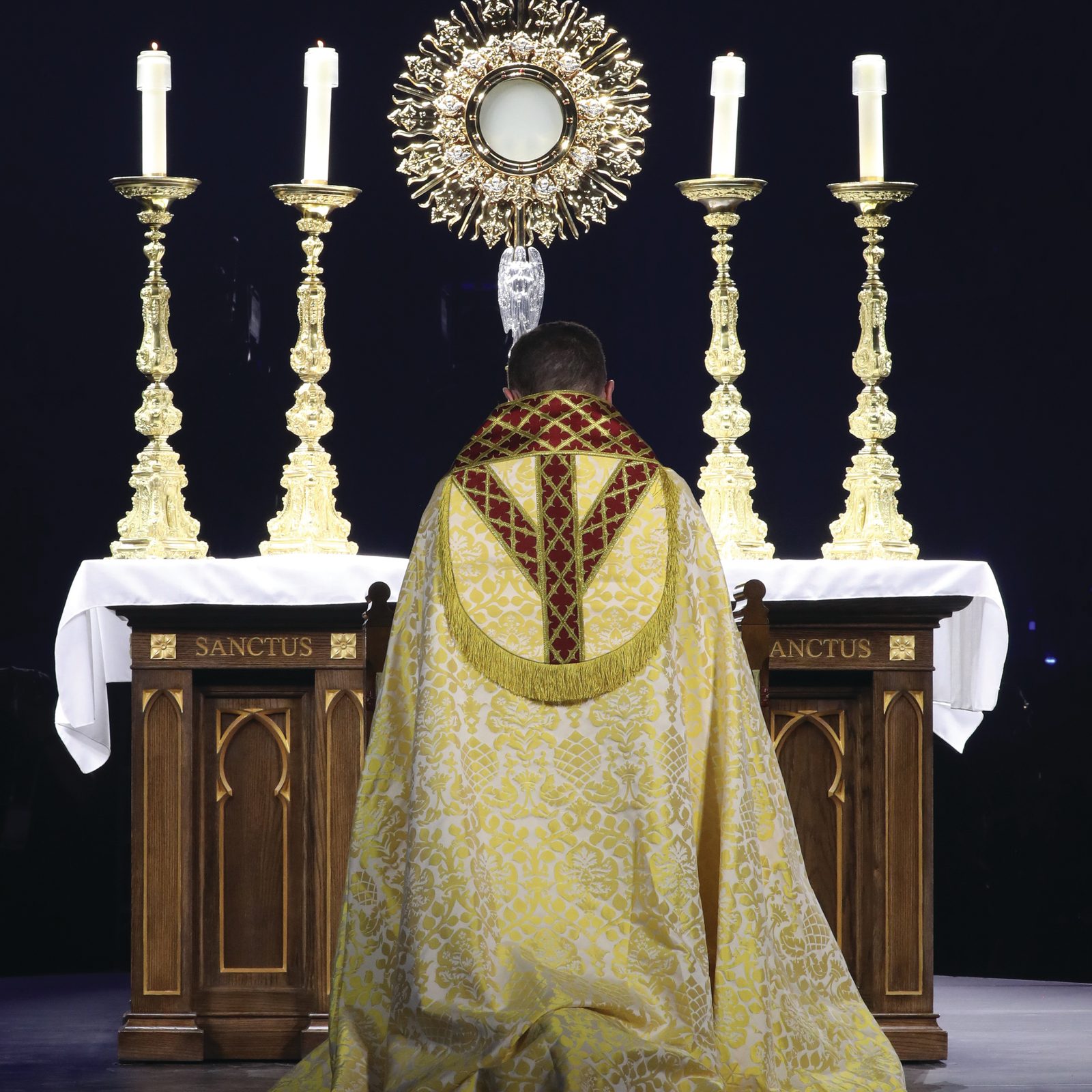 Bishop Andrew H. Cozzens of Crookston, Minnesota, chairman of the board of the National Eucharistic Congress, Inc., kneels in prayer before the monstrance during Eucharistic adoration at the opening revival night July 17, 2024, of the 10th National Eucharistic Congress at Lucas Oil Stadium in Indianapolis. (OSV News photo/Bob Roller)