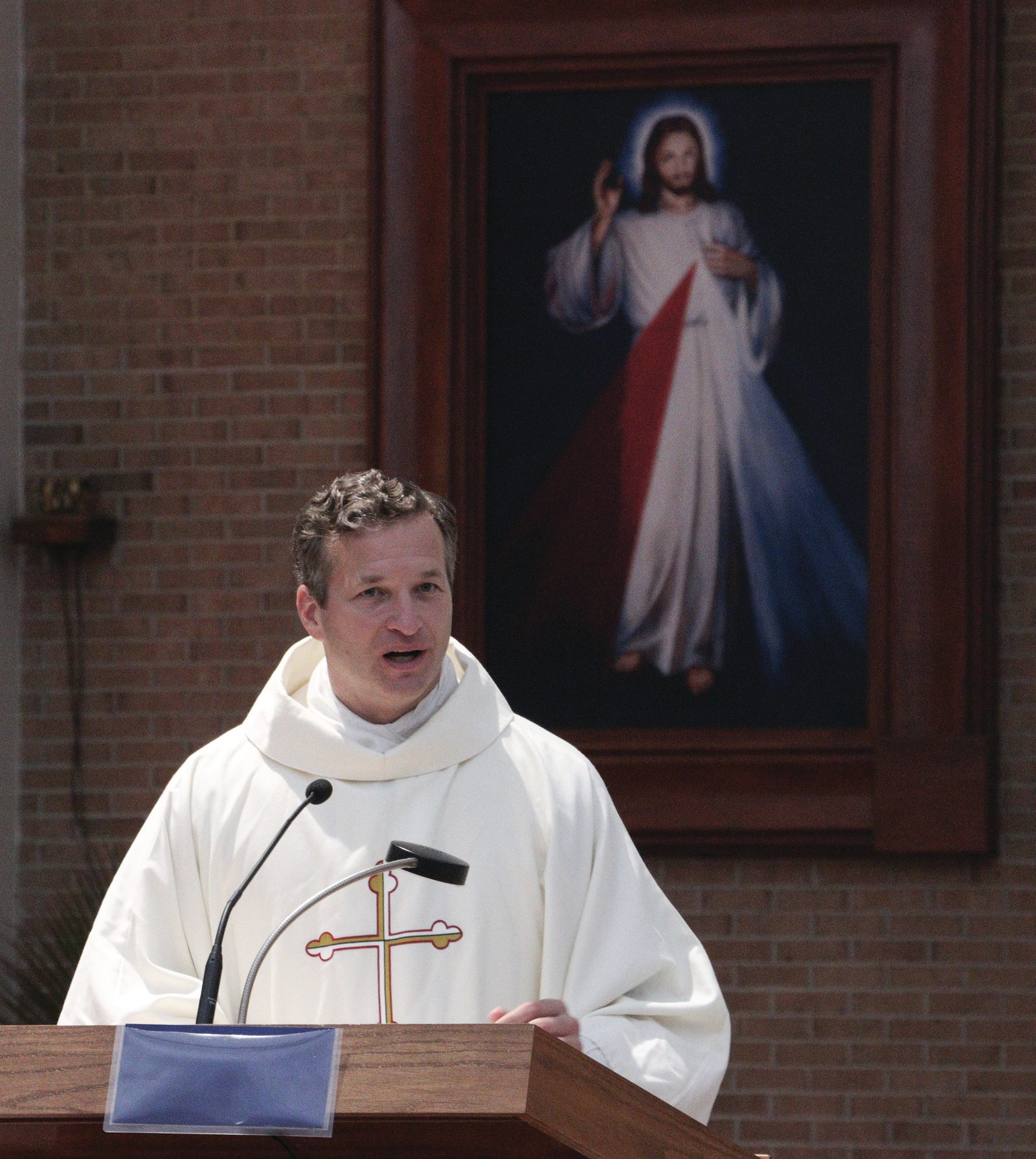 Above, Father Mark Ivany, the director of priest vocations for The Roman Catholic Archdiocese of Washington, speaks at the Seminarian Family Day Mass on July 27, 2024 at St. Mary’s Church in Landover Hills, Maryland. Below, family members pray during the Mass. (Catholic Standard photos by Javier Diaz)