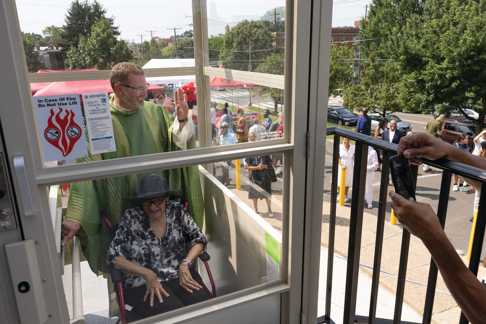 After cutting a ribbon cutting ceremony at Nativity Church, Father Pawel Sass, pastor of the parish, accompanies parishioner Constance Dickerson Aug. 17 on the first ride of the newly blessed elevator. (CS photo by Andew Biraj)