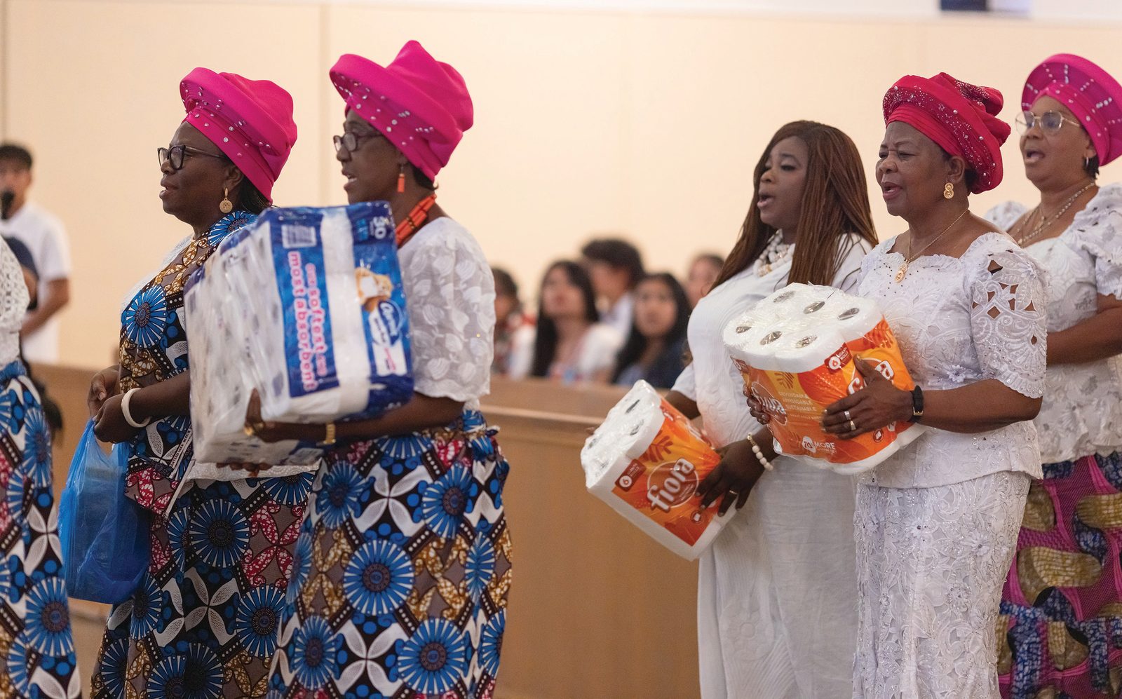 Above, St. Bernard parishioners in traditional African garb present household items as part of the procession of offertory gifts during the Aug. 17 Mass marking the 75th anniversary of the parish. Below, young girls in native costume pray during the Mass. (Catholic Standard photos by Rachel Lincoln)