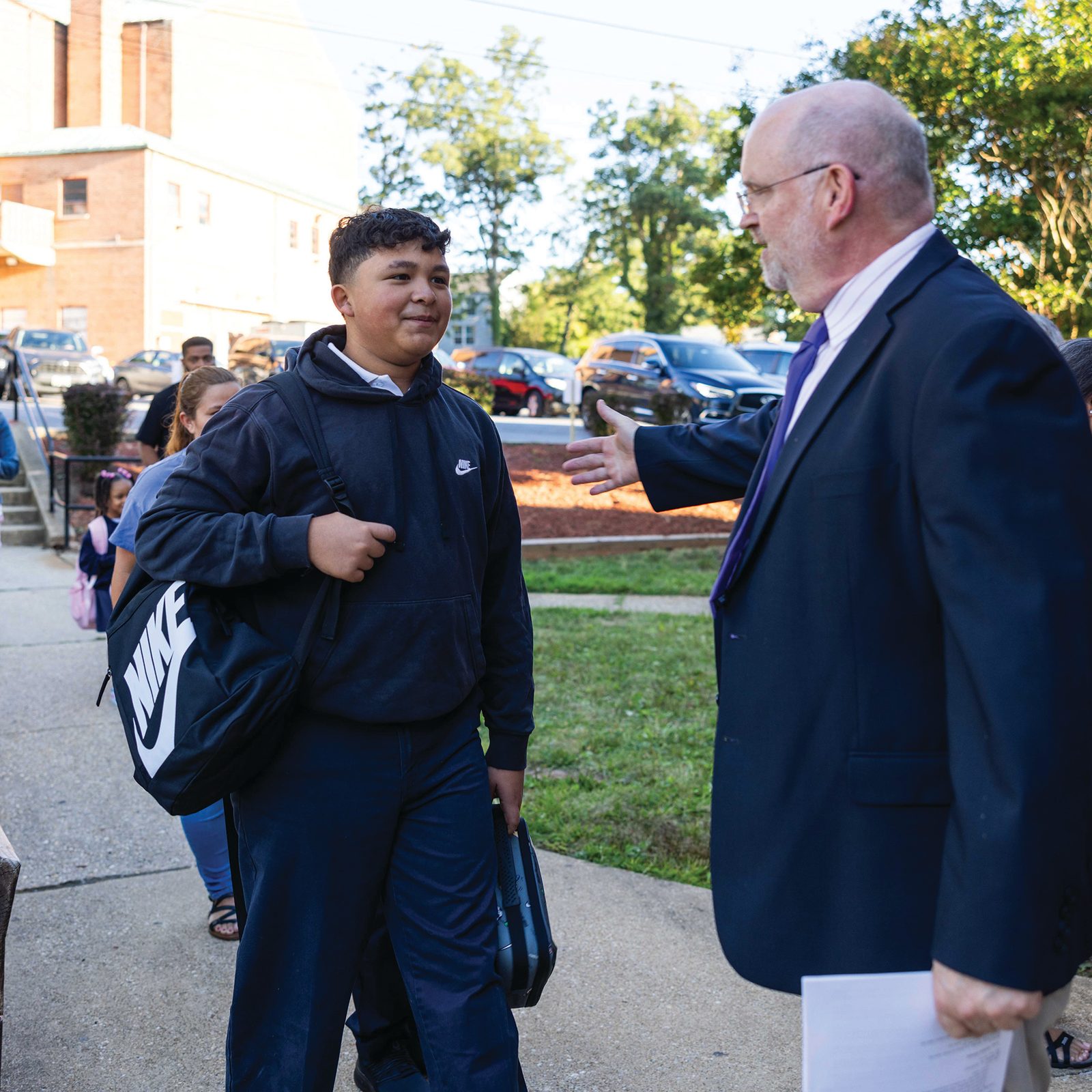 Dr. Philip Robey, the fourth-year principal at St. Ambrose School in Cheverly, Maryland, greets seventh grader Erickson Hernandez on the first day of classes, Aug. 26, 2025. (Catholic Standard photo by Andrew Biraj)