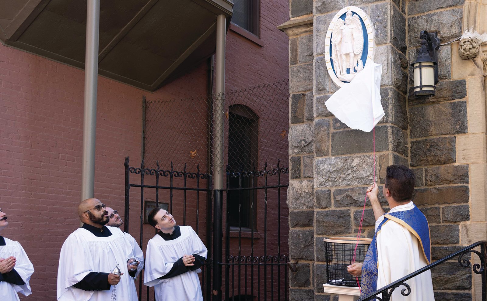 Father Vincent De Rosa, unveils a street shrine to St. Michael the Archangel, defender of God’s People, Patron of Police, during a Sept 28 dedication and blessing at St. Mary Mother of God Catholic Church in Washington. (CS photo by Andrew Biraj)