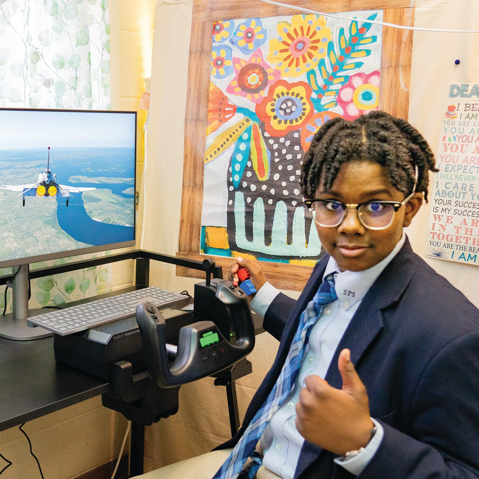 Eighth grader Christian Turner gives a thumbs-up while navigating a flight simulator in the STEM classroom at St. Peter’s School in Waldorf, Maryland. The flight simulators are part of the school’s innovative program to introduce students to aviation and aerospace concepts. (Catholic Standard photo by Nicole Olea)