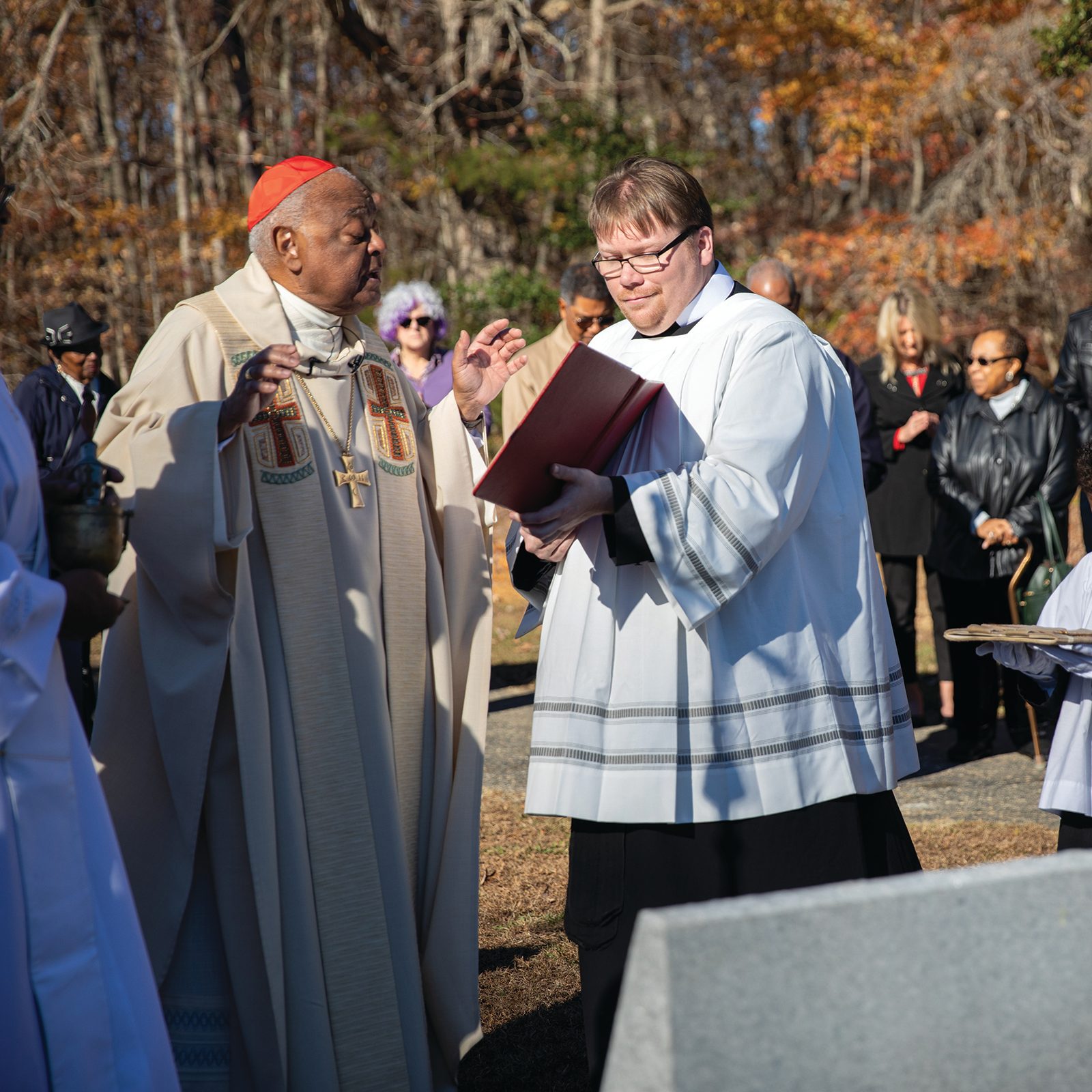 Washington Cardinal Wilton Gregory blesses a memorial marker on Nov. 26, 2022 honoring the unknown enslaved people buried at the St. Peter Claver Parish cemetery in St. Inigoes, Maryland. Standing beside him is Father Joseph Tyson Murphy, the interim director of the archdiocese’s Office of Worship. At right is St. Peter Claver altar server Cameron Butler. (CS file photo by Ashley Barnas)