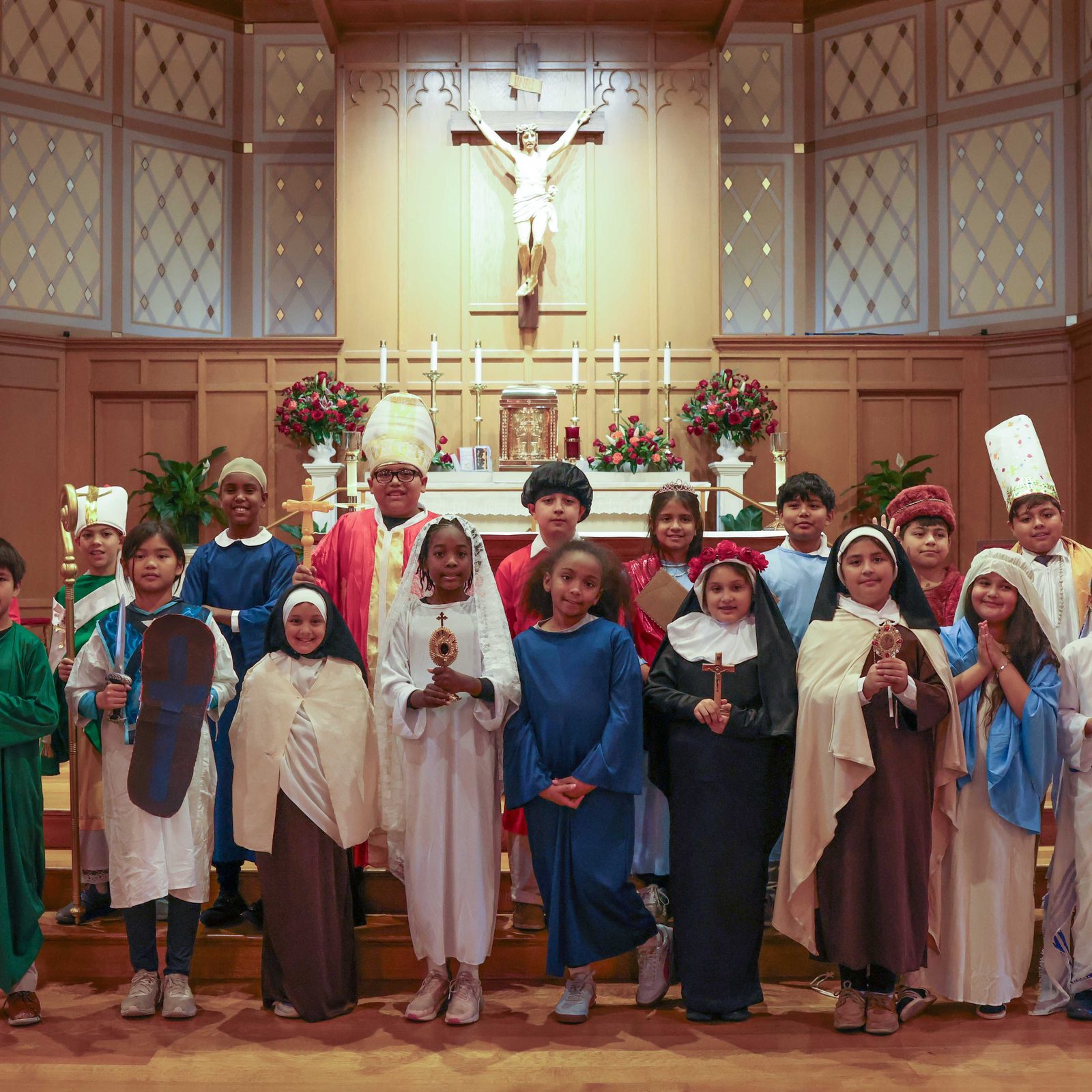 After a Nov. 11, 2025 Mass for students of St. Martin of Tours School in Gaithersburg, Maryland, to celebrate the feast day of their patron saint, St. Martin’s fourth graders who dressed up as saints to mark the day and All Saints Day posed together for a photo in front of the altar at the parish church. (Catholic Standard photo by Andrew Biraj)