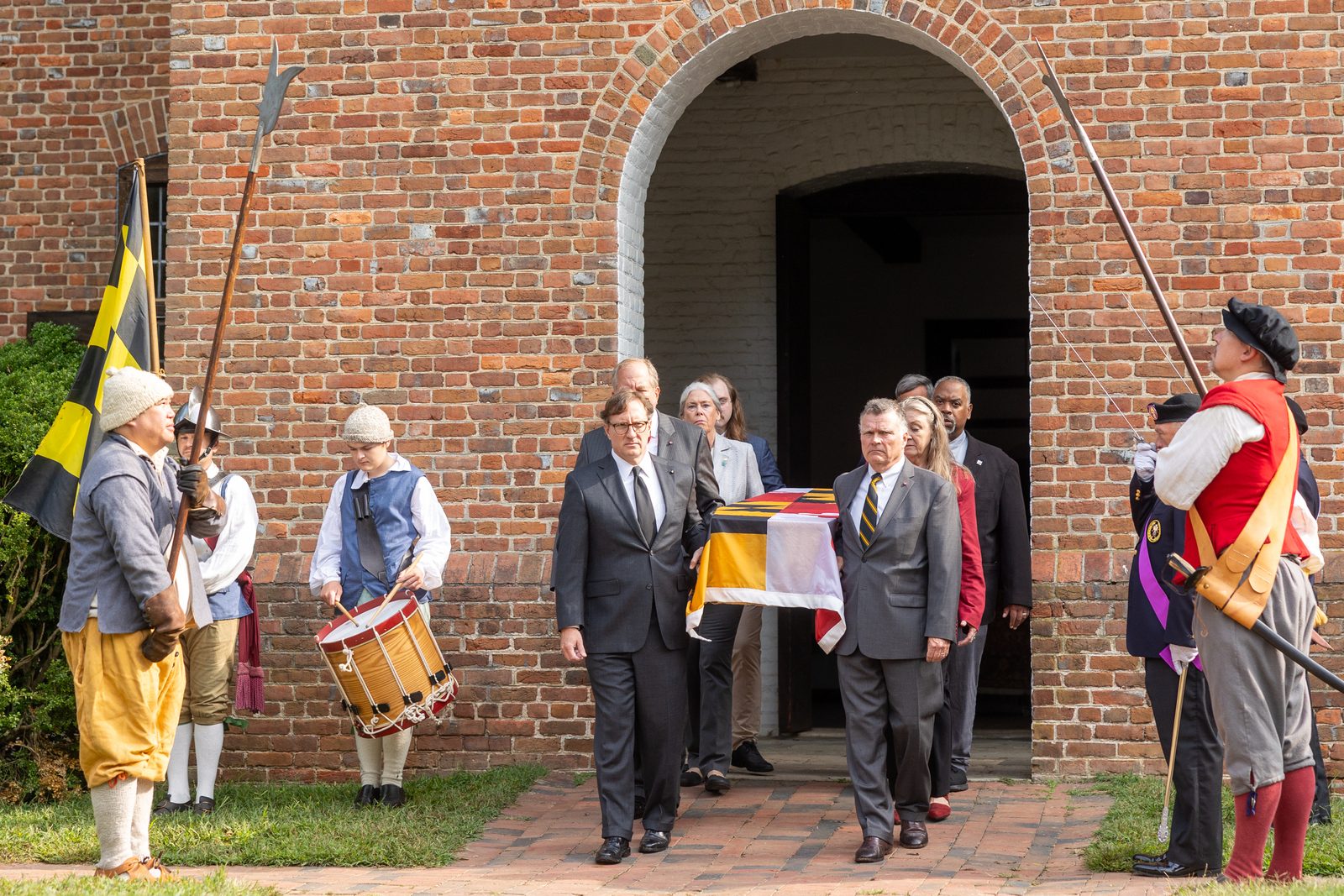 Eight honorary pallbearers who are descendants of 17th century Marylanders carry the pine coffin bearing the remains of eight young children from colonial-era Maryland at the beginning of a procession on Sept. 20, 2025 from the reconstructed State House of 1676 in Historic St. Mary’s City to the rebuilt 1667 Brick Chapel about one-half mile away. At the chapel, Baltimore Archbishop William E. Lori presided at a reinterment rite, marking the return of the remains of those eight young children at the site. In the early 1990s, the remains of 65 early Marylanders buried near the foundation of the original chapel were removed so they would not be damaged during the construction of the rebuilt chapel. (Catholic Standard photo by Mihoko Owada)